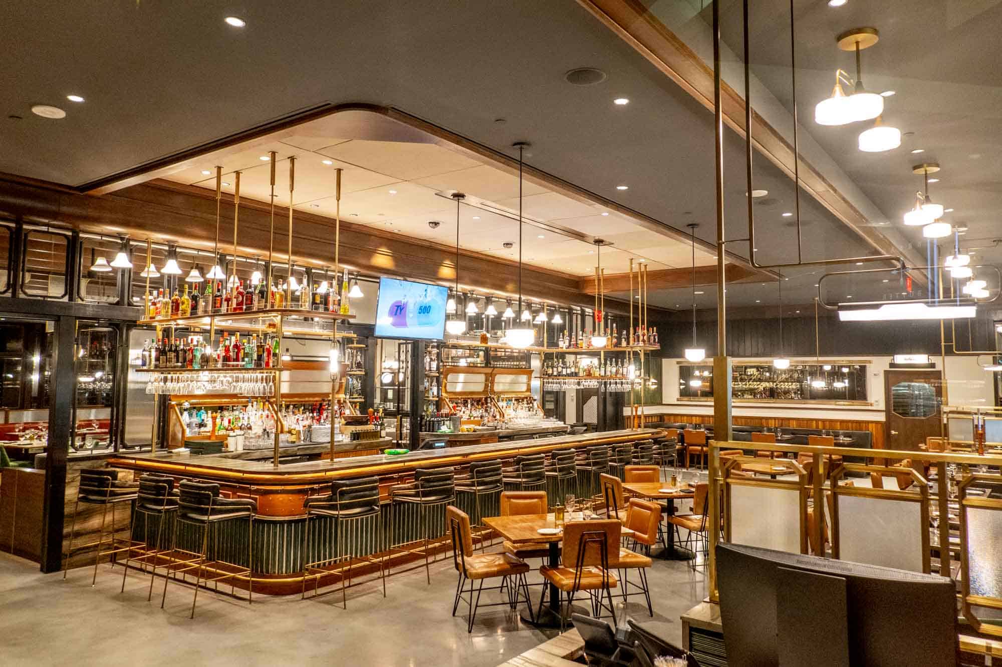 Interior of a brightly-lit restaurant with a large illuminated bar.