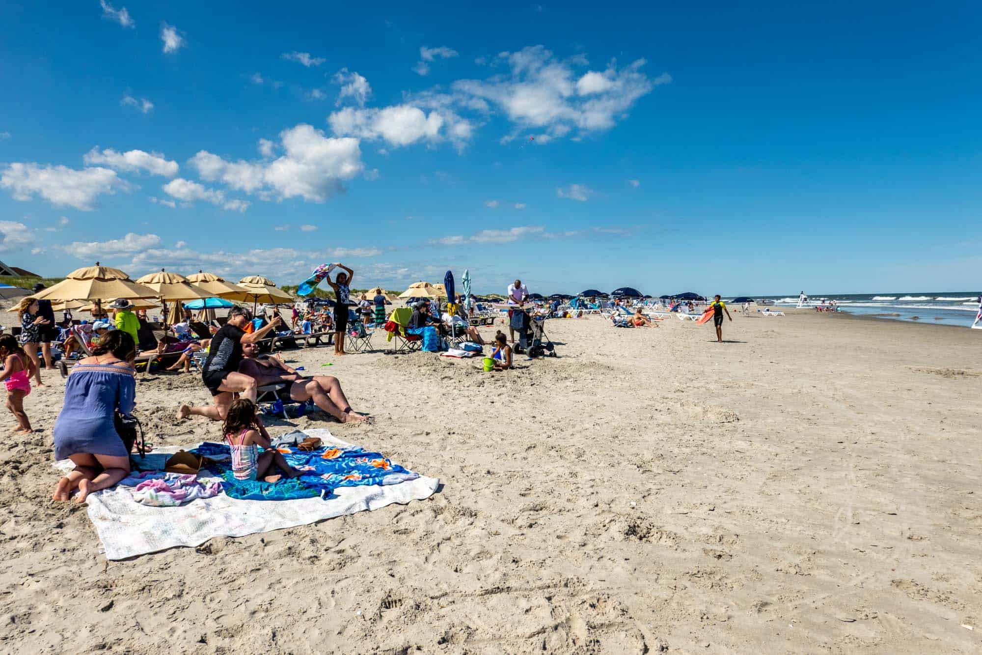 People sitting on towels and in chairs at the beach in Avalon NJ