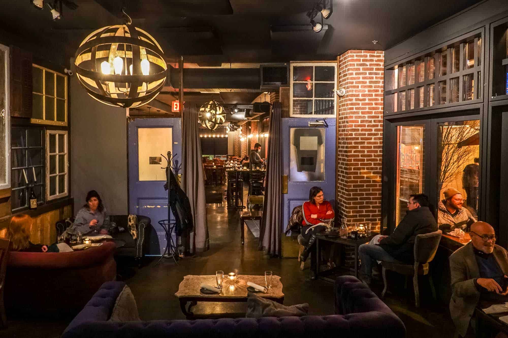 People seated inside a bar and lounge at night.