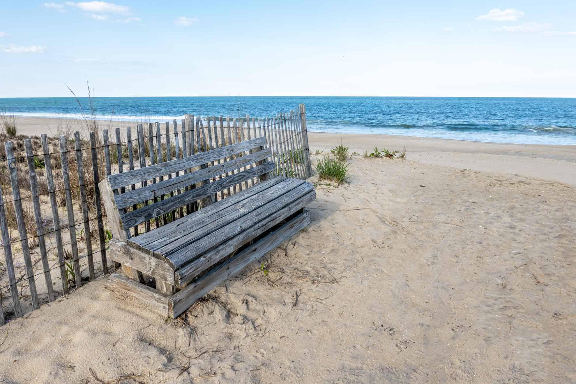 Wooden bench and seagrass on the beach.