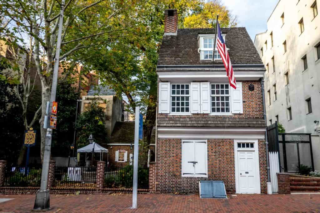 Two-story brick house with white shutters flying the American flag