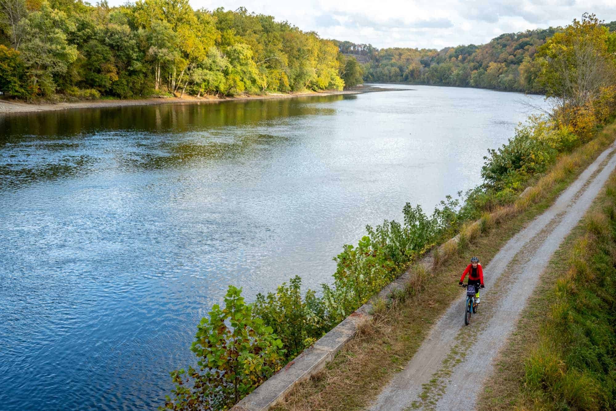 Bicyclist on a path beside a river.