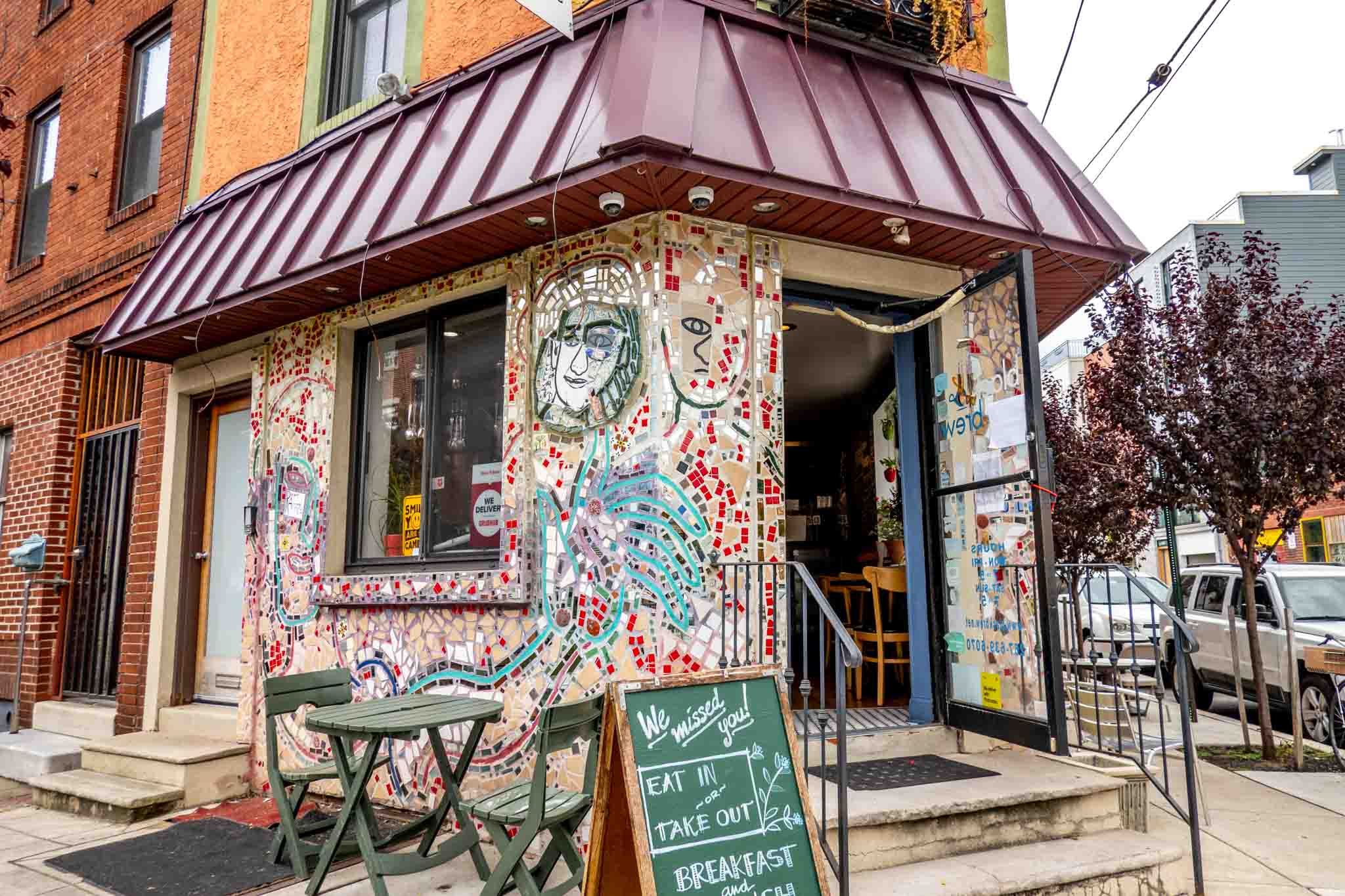 Cafe exterior covered in multi-colored mosaic tiles.