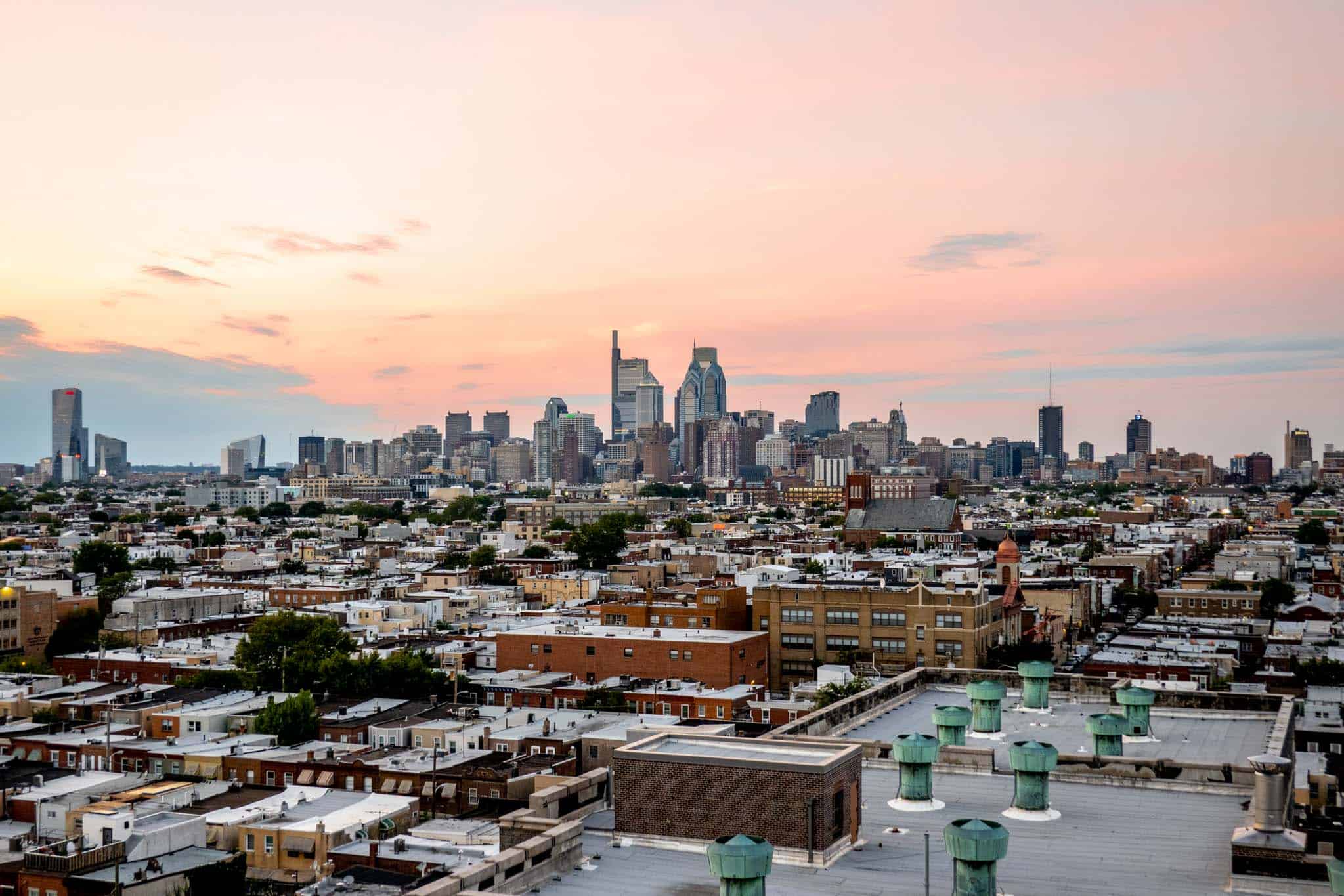 Orange and pink sunset over a city skyline.