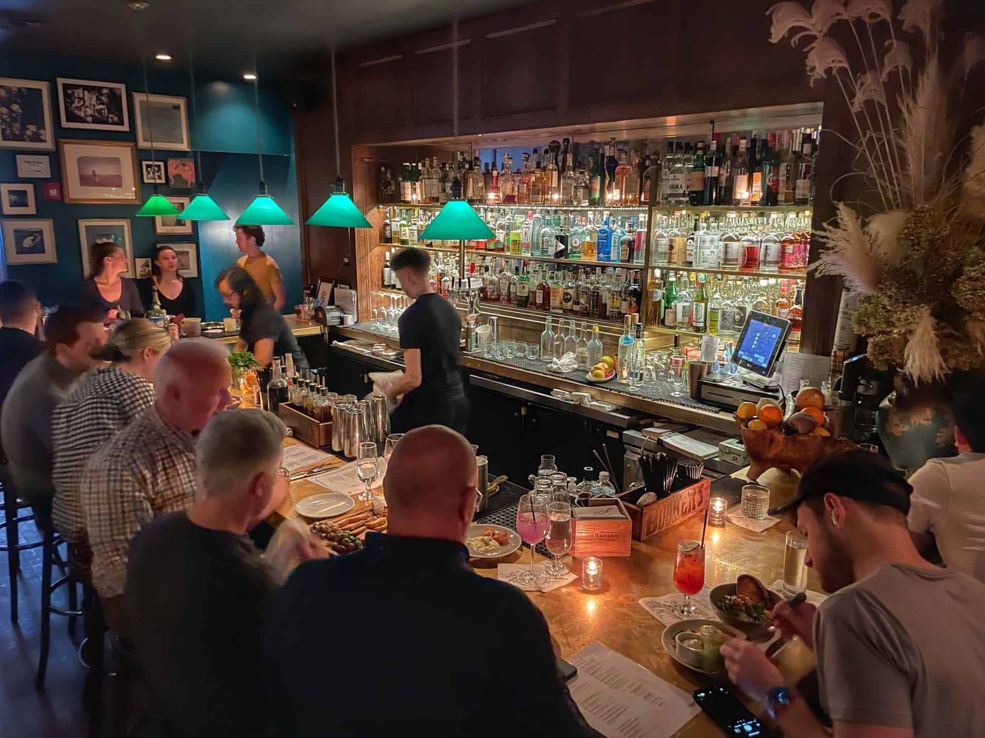 People eating at a busy, dimly-lit bar.