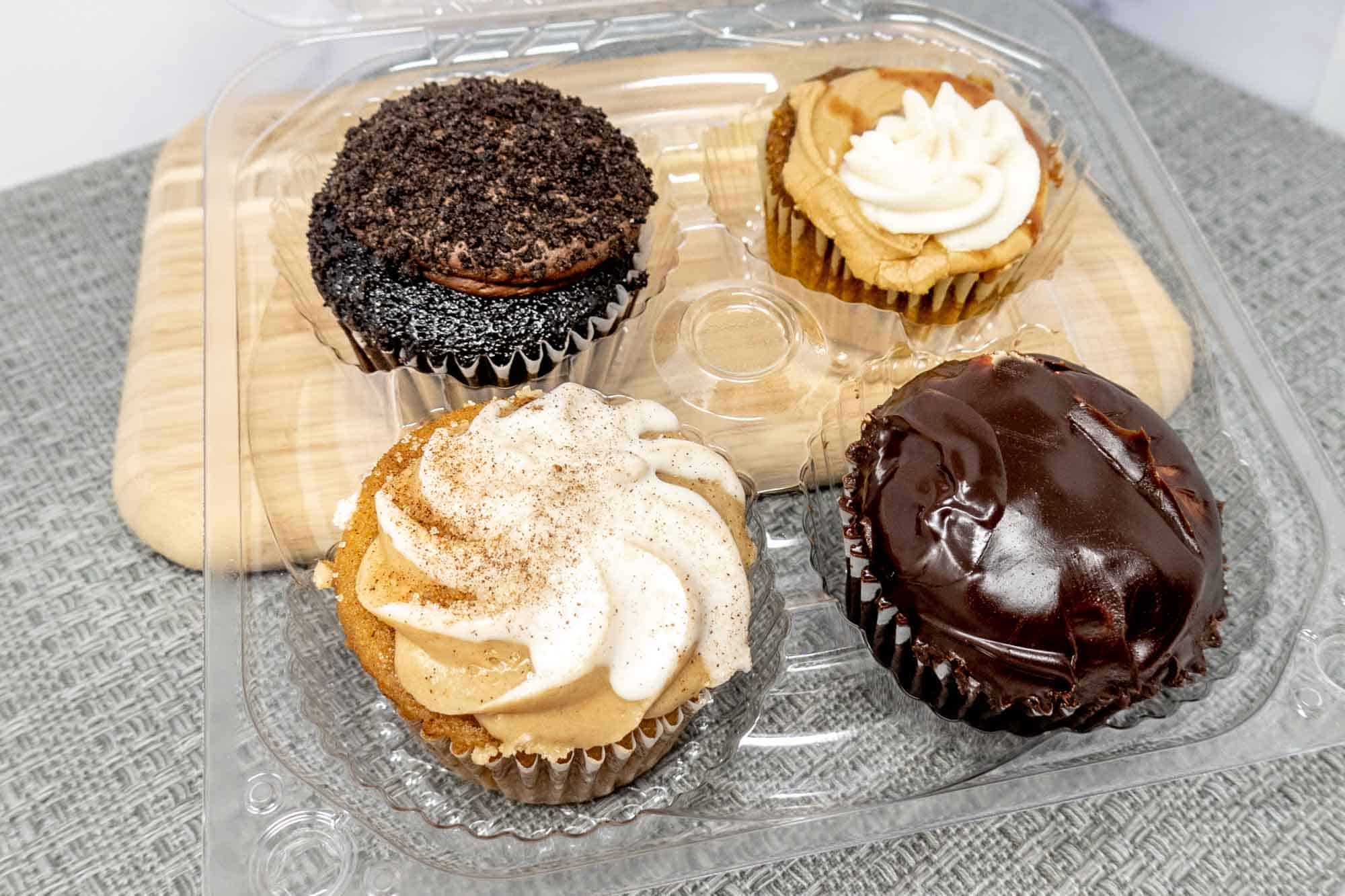 Container with two chocolate and two vanilla cupcakes.