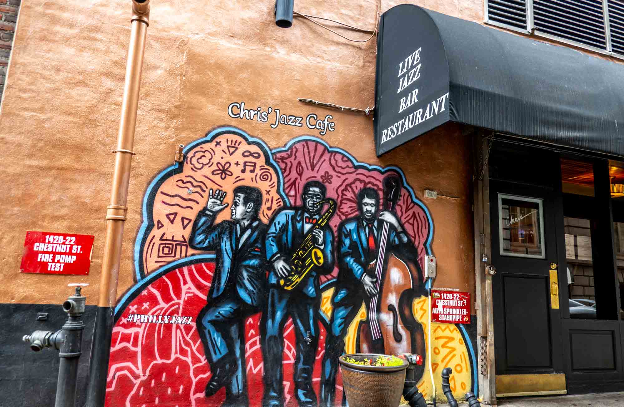 Mural of three jazz musicians outside Chris' Jazz Cafe.