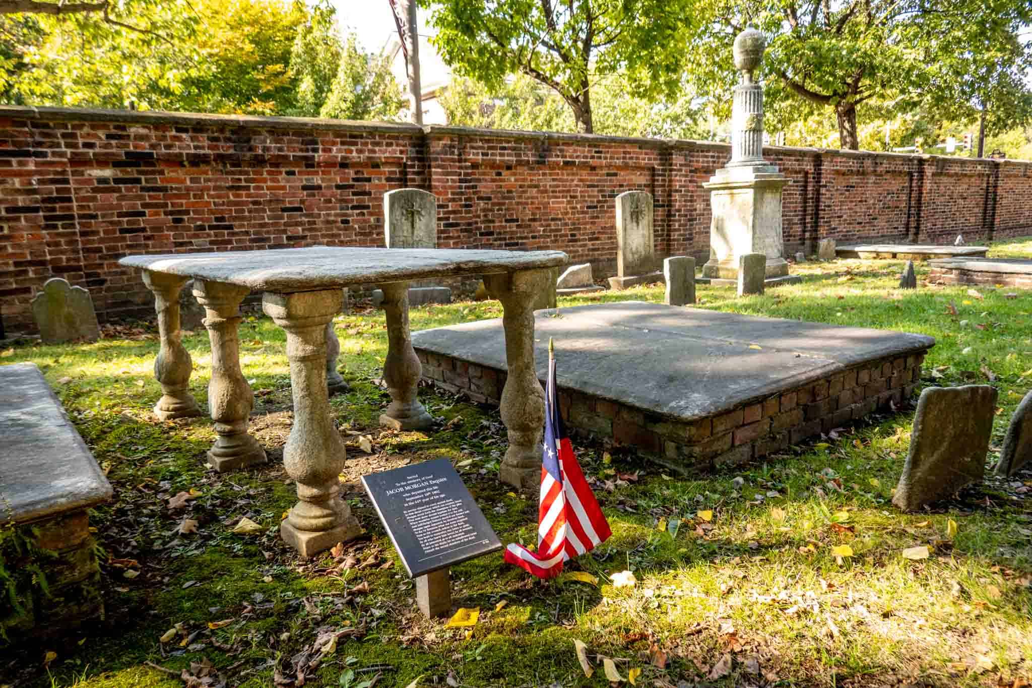 Table-shaped grave marker with a plaque with information about Jacob Morgan marked with an American flag