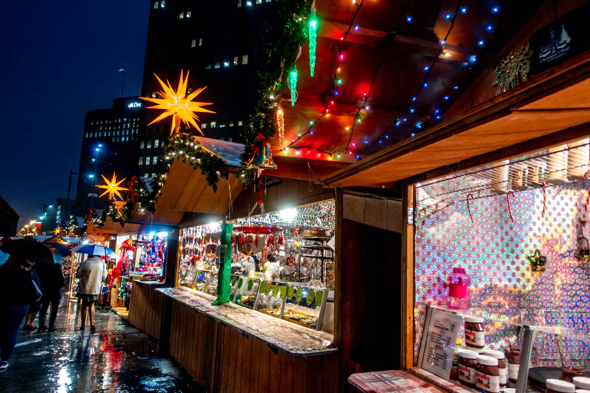 Wooden vendor huts decorated with lights.