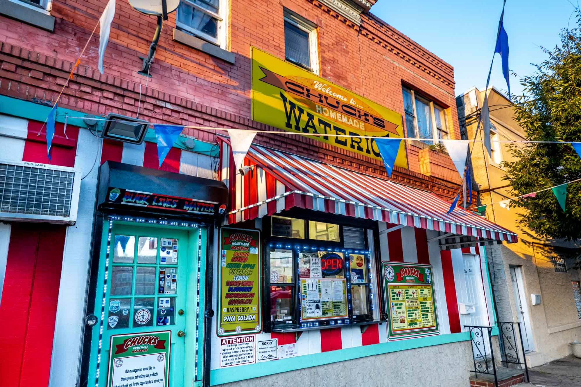 Storefront with a red and white striped awning and a sign: "Welcome to Chuck's Homemade Water Ice."