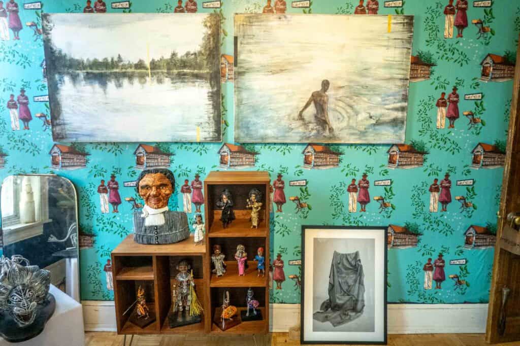 Paintings and wire sculptures displayed in the bedroom of The Colored Girls Museum.