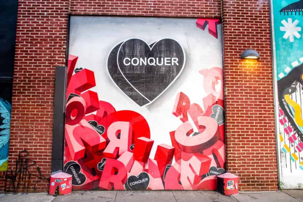 Philly street art mural by Amberella saying "Conquer"