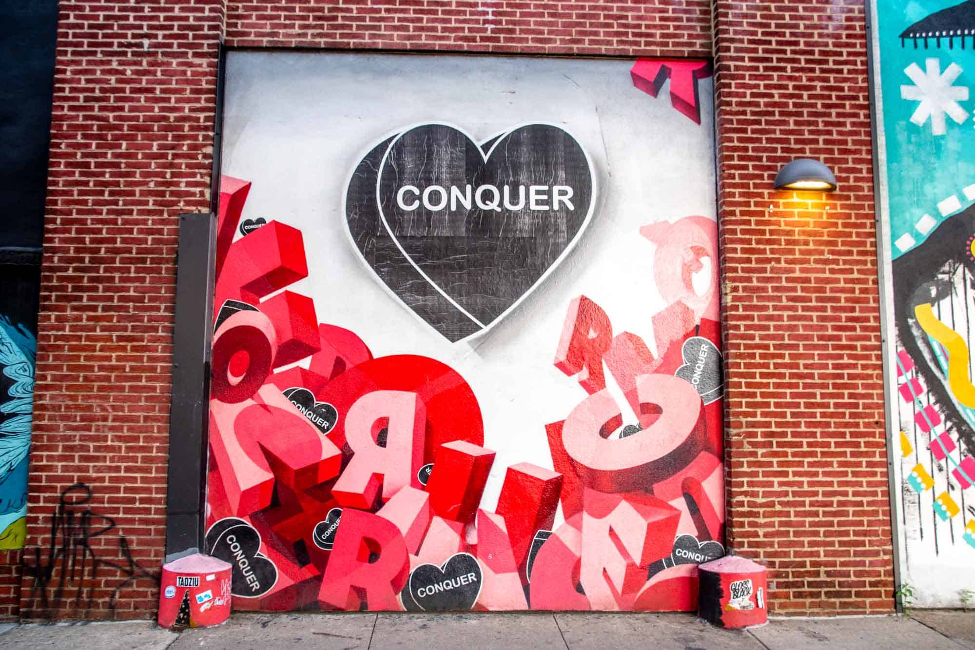 Mural saying Conquer by artist Amberella