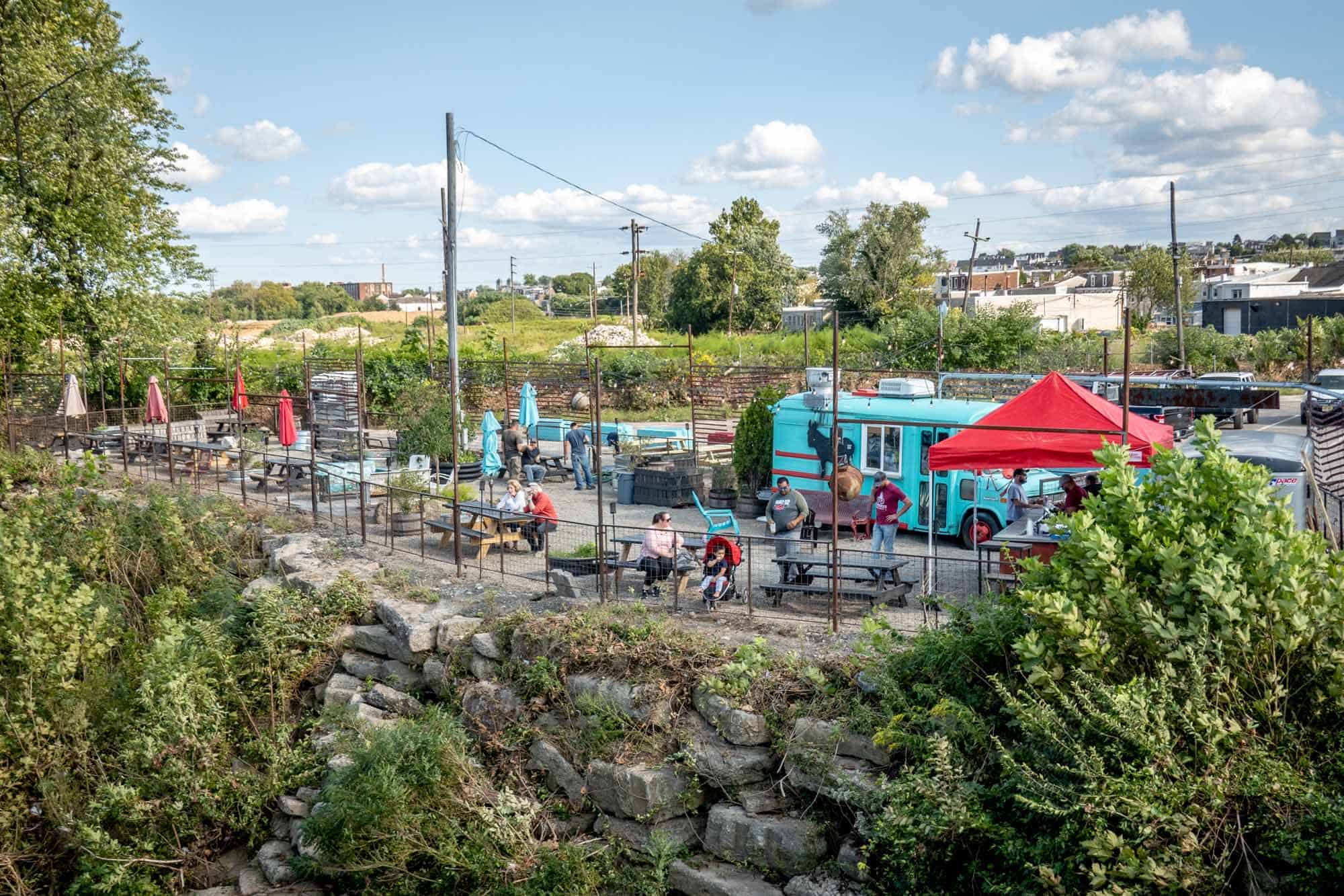 People in outdoor beer garden with bright blue mini-bus