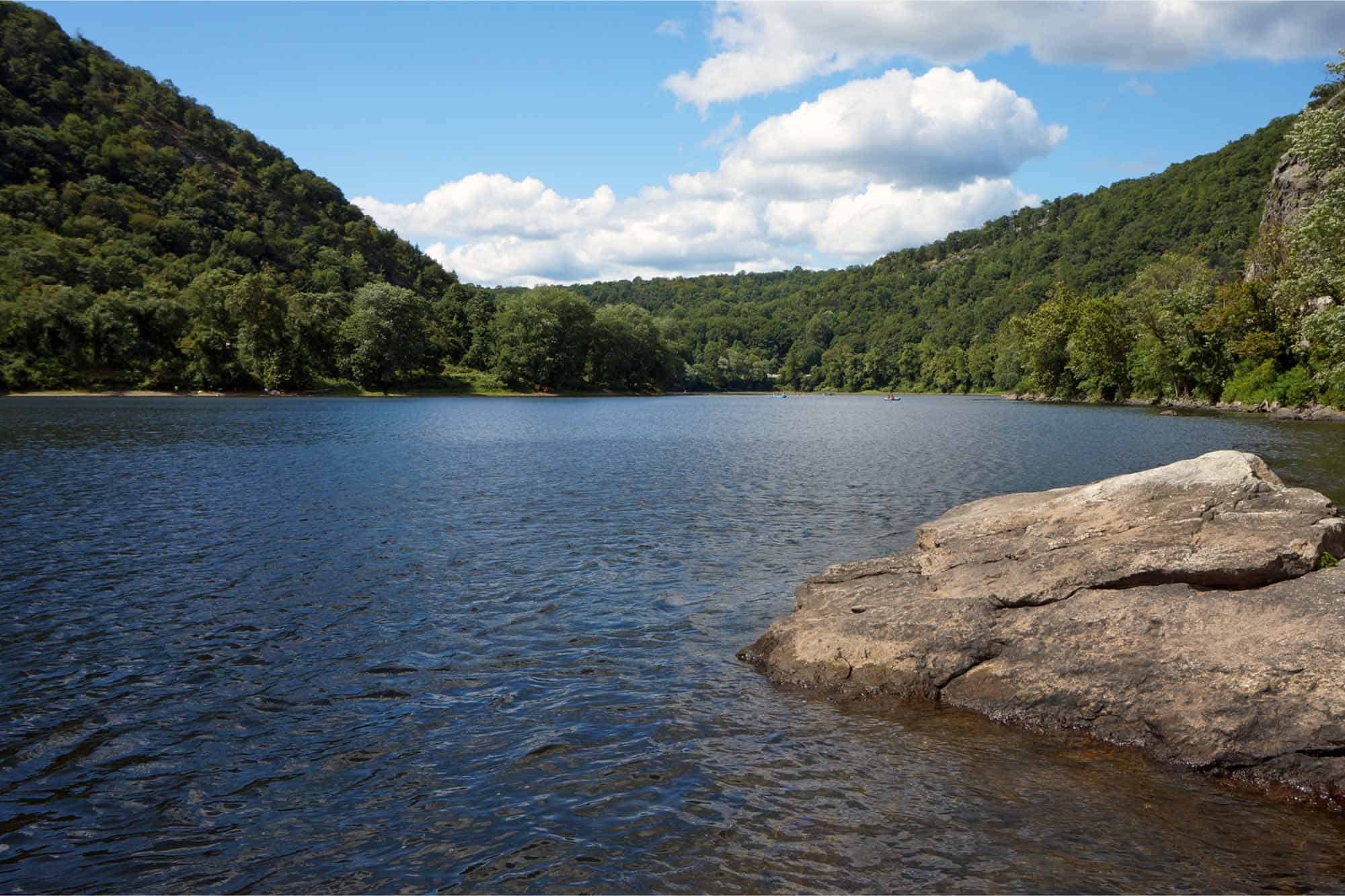 Big rock in lake between hills
