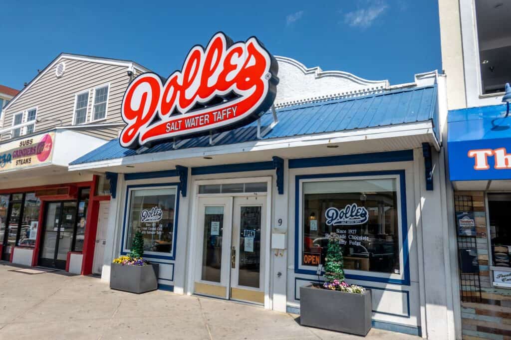 White building with blue roof in Rehoboth Beach and a red sign: "Dolle's Salt Water Taffy"