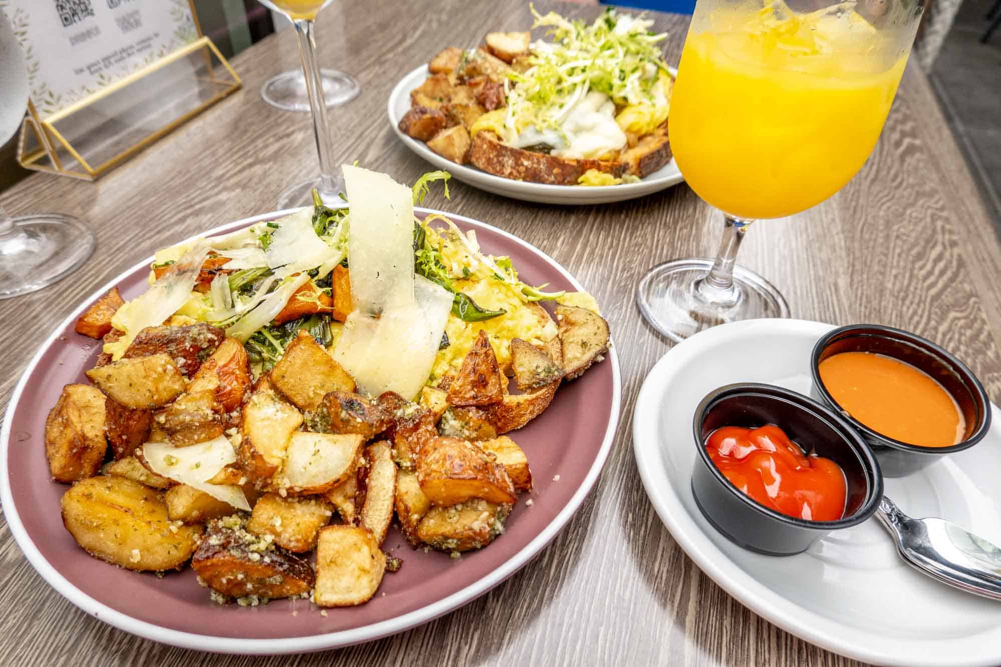 Two plates of eggs and potatoes on a table. 