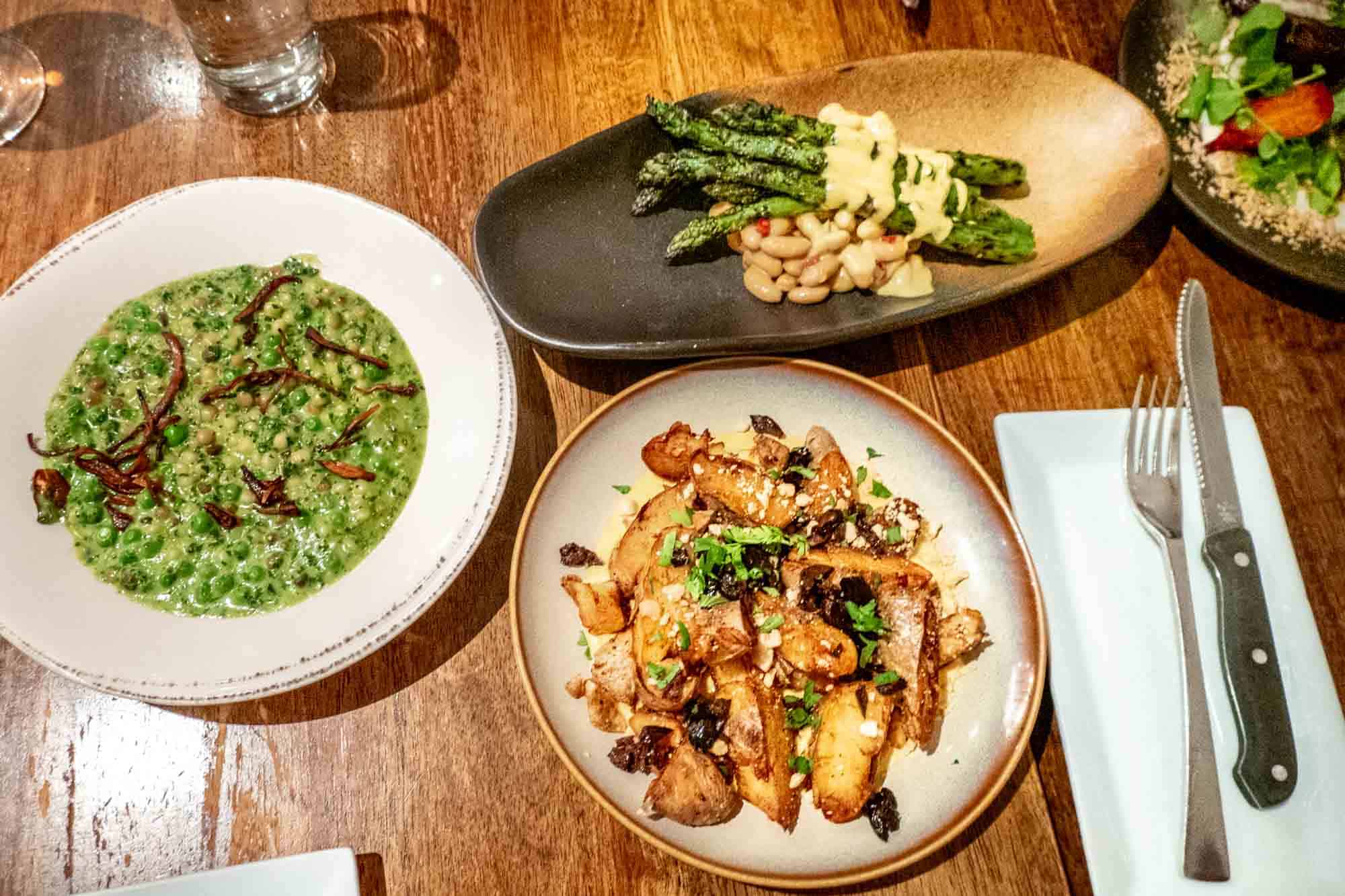 Plates of vegetables on a wooden table.