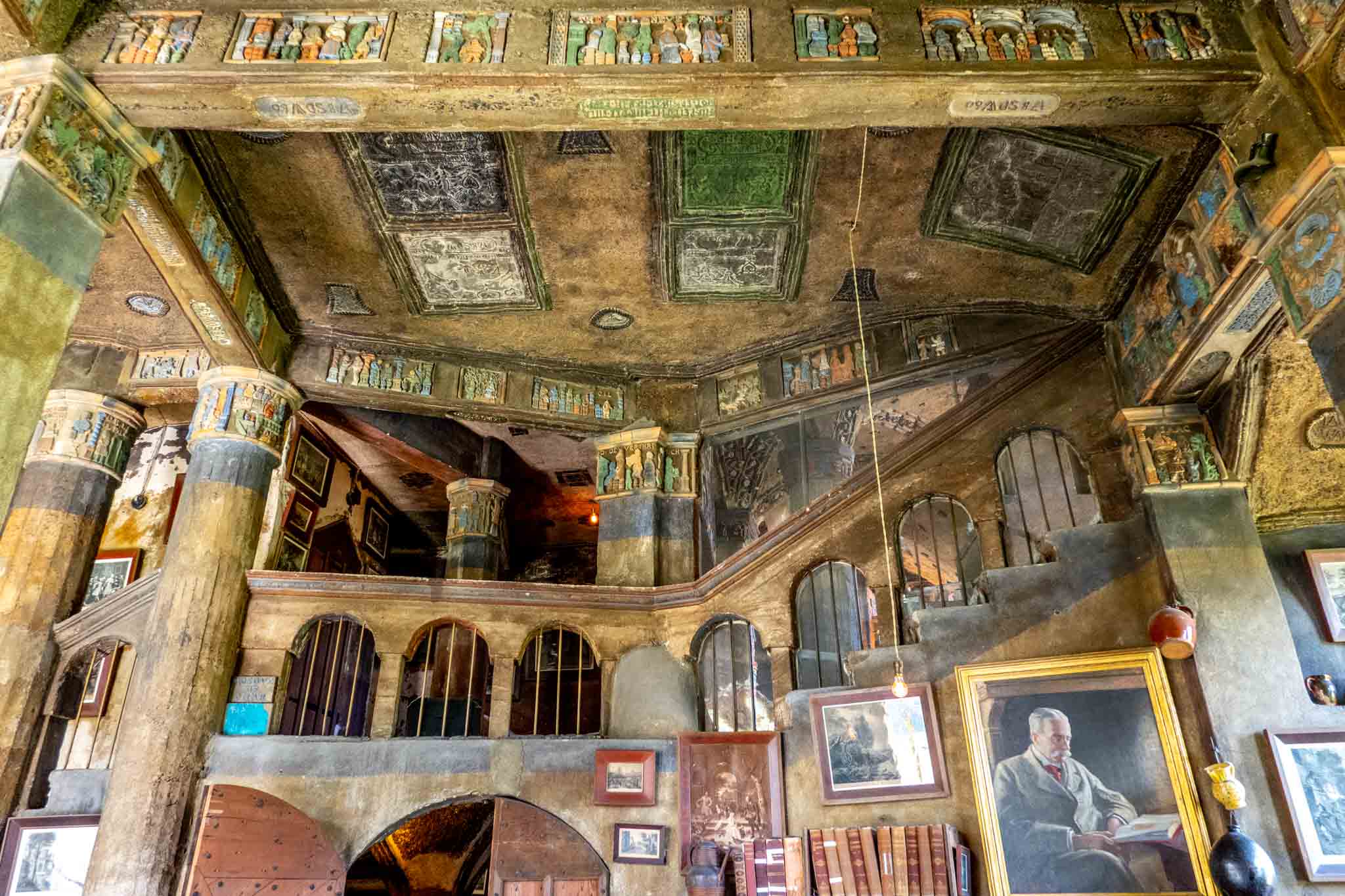 Two-story room with a large staircase and tiled ceiling.