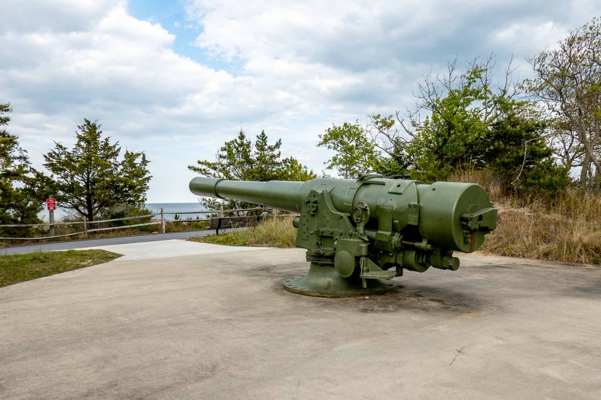 Large piece of World War II artillery on display outdoors.