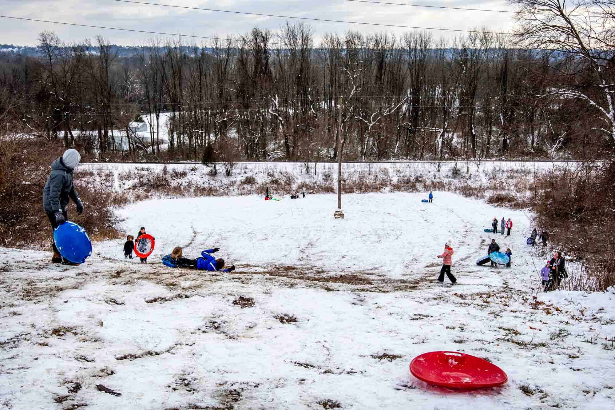 People sledding down a snow-covered hill