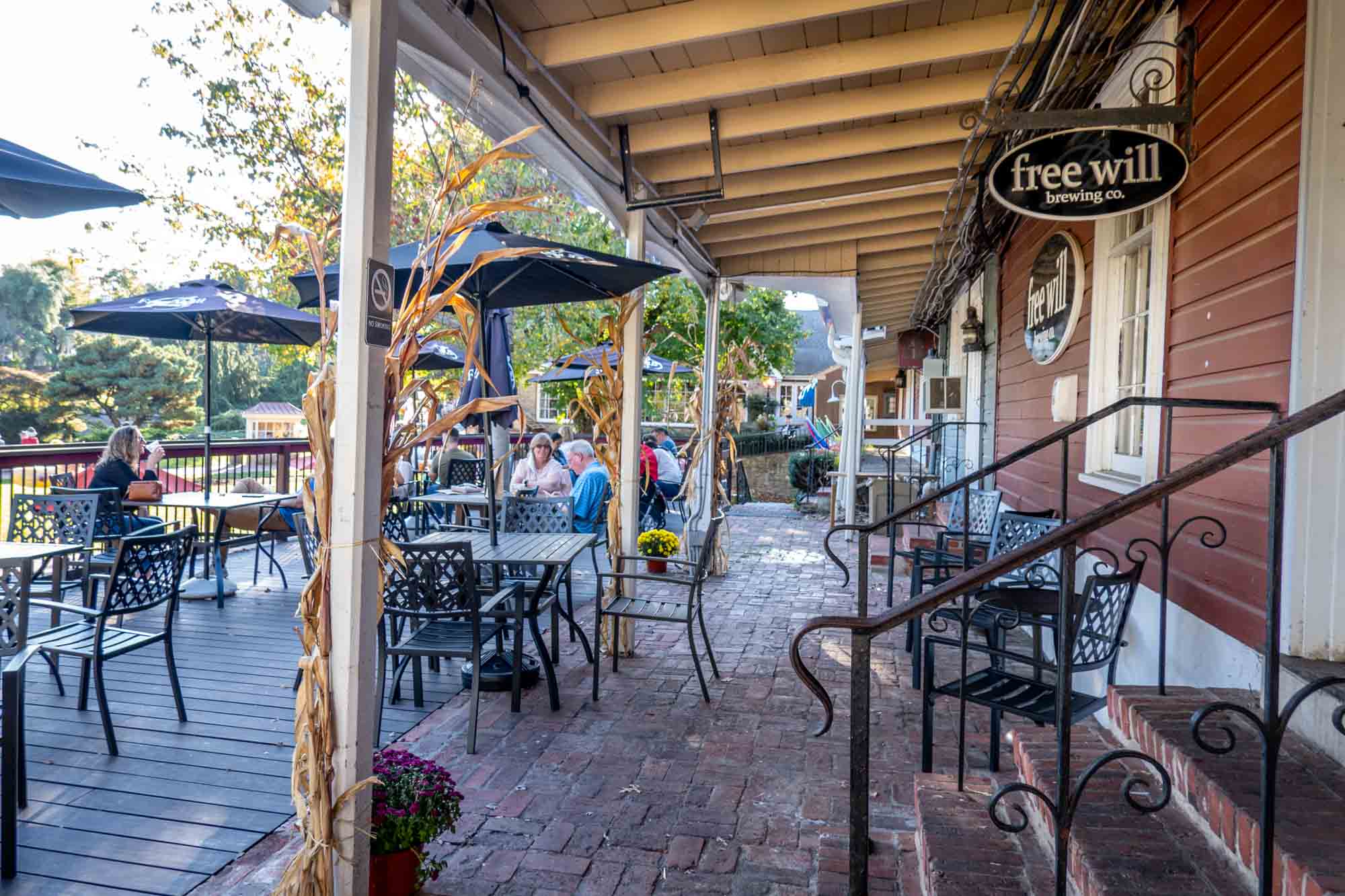 People on patio under shade umbrellas at Free Will Brewing Co.