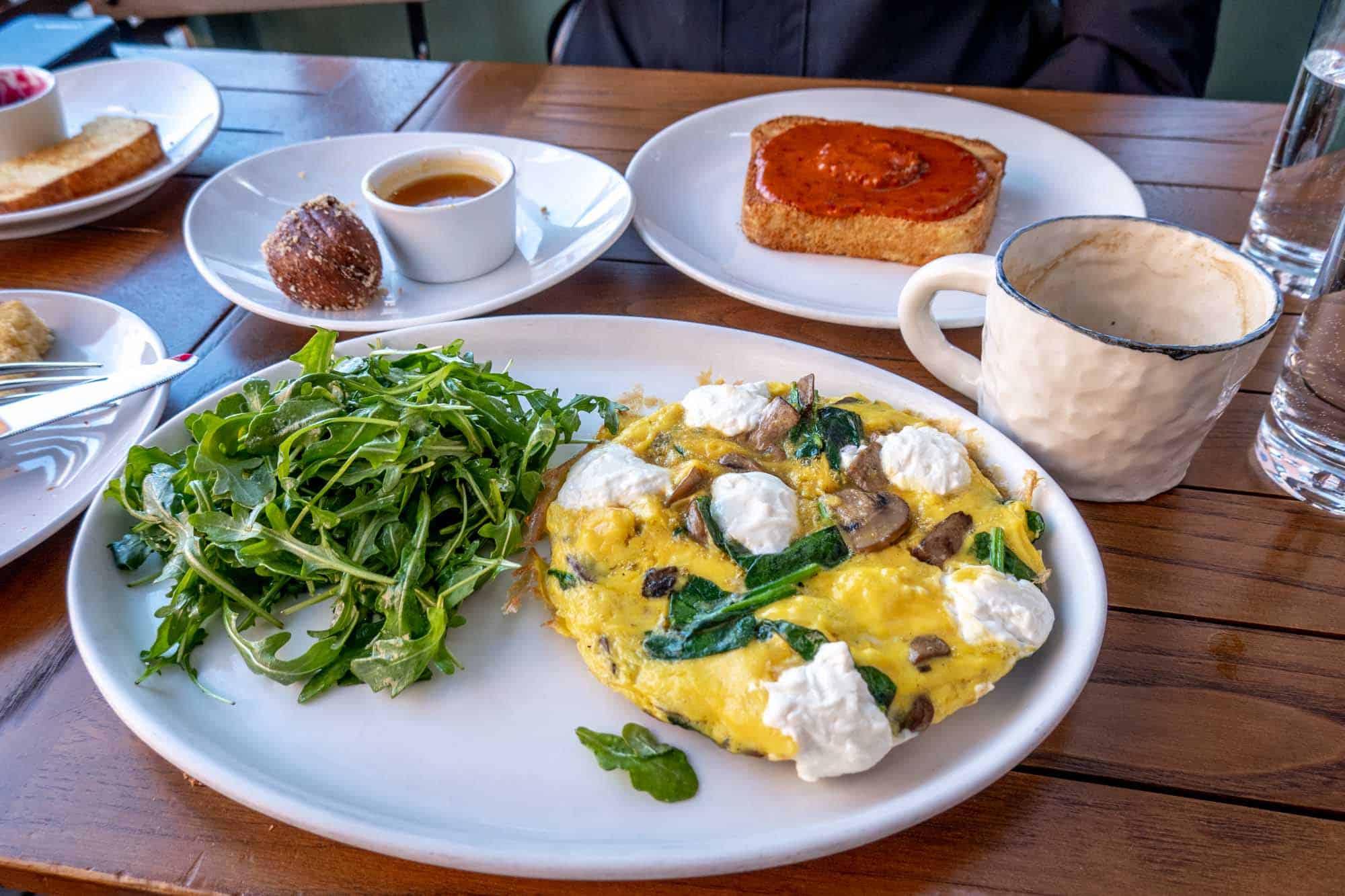 Plates with beignets, toast, a fritatta, and other brunch food.