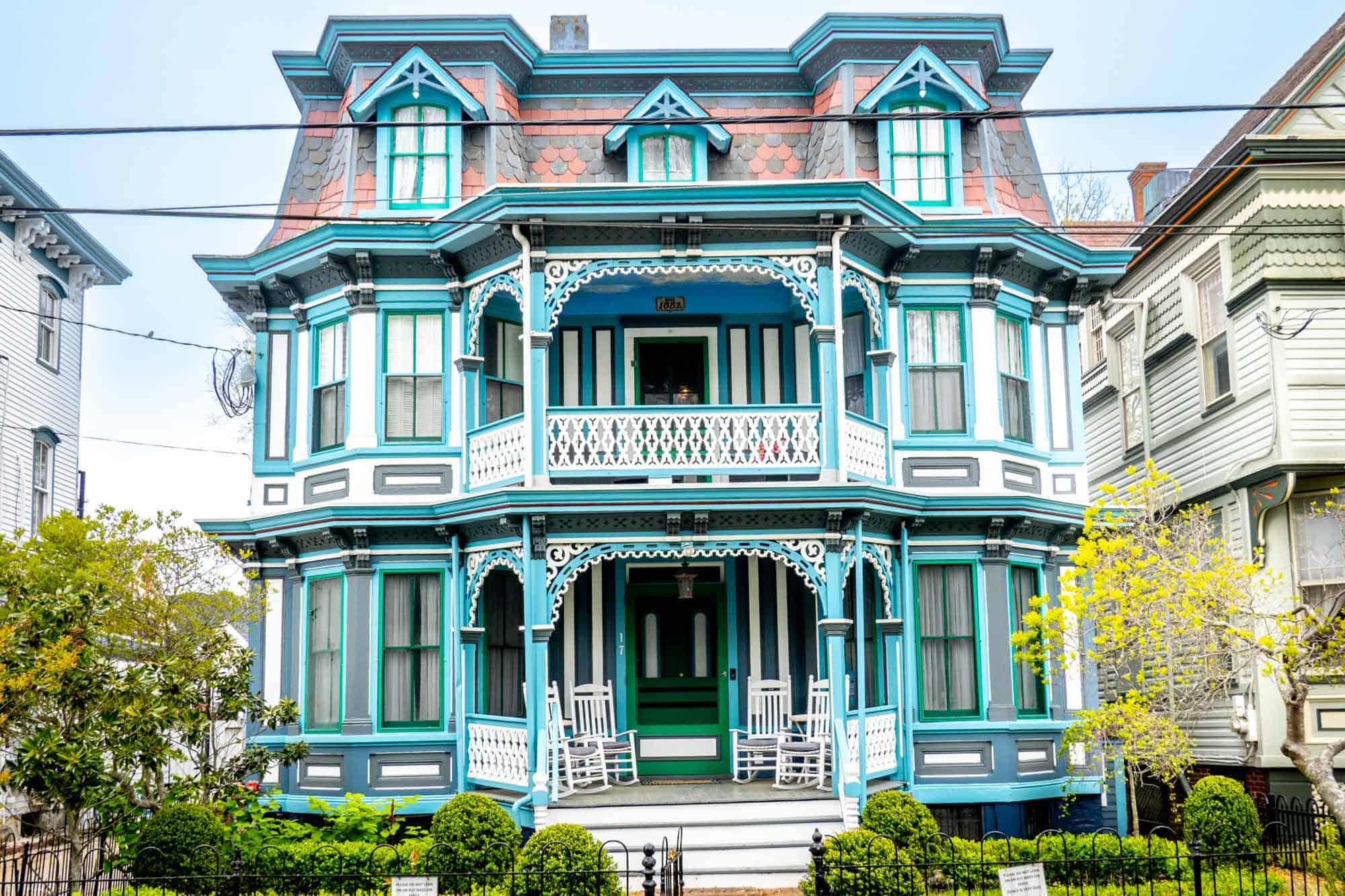 Three-story Victorian home painted blue, white, and turquoise