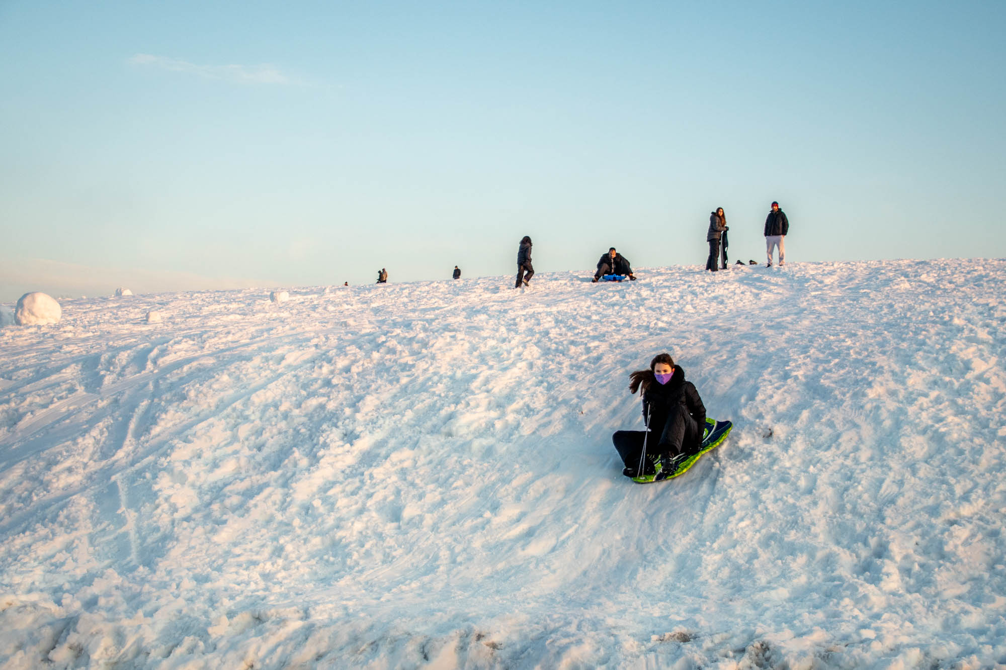 People sledding on a snowy hill