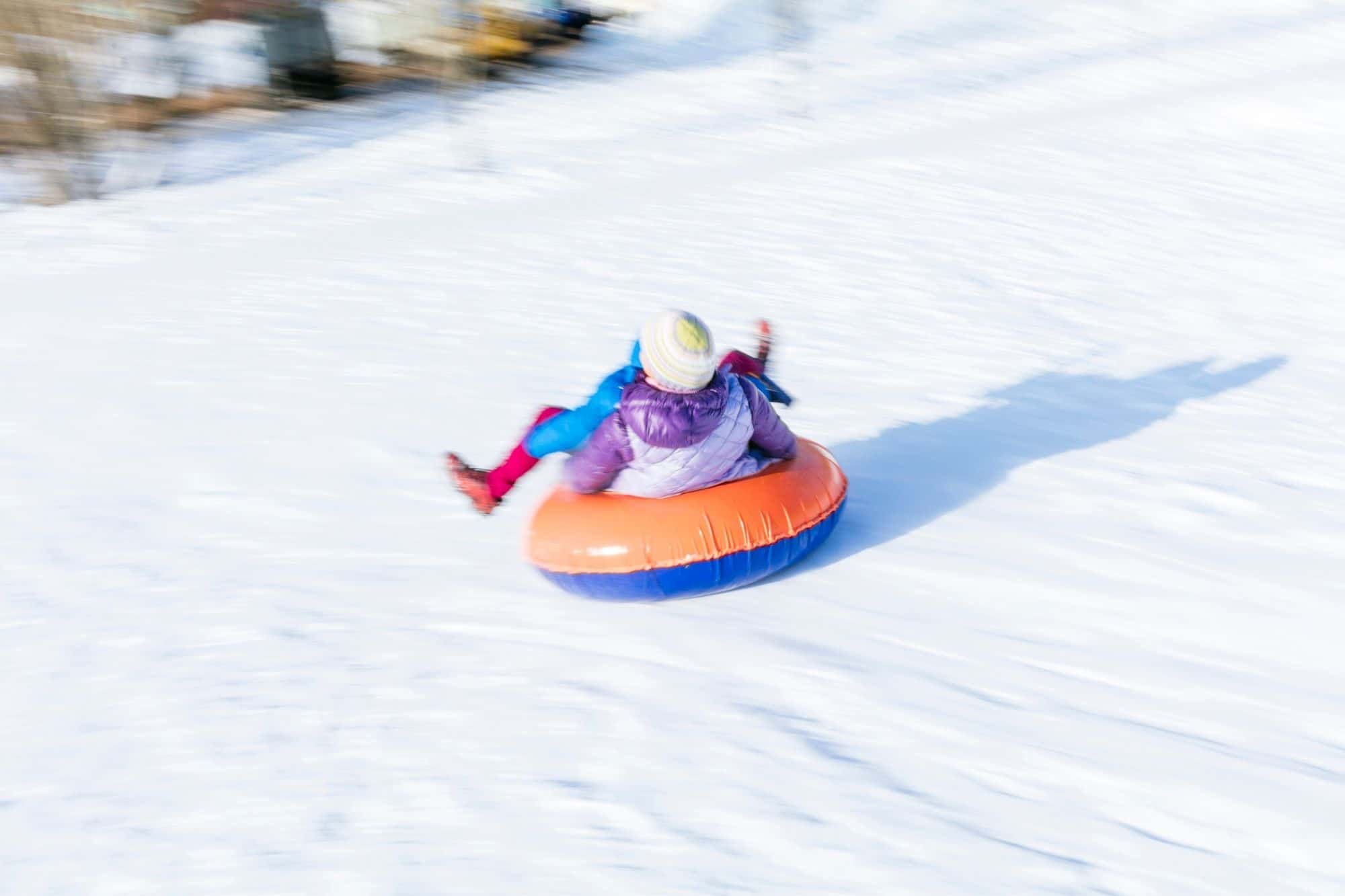 Child moving fast on a snow tube