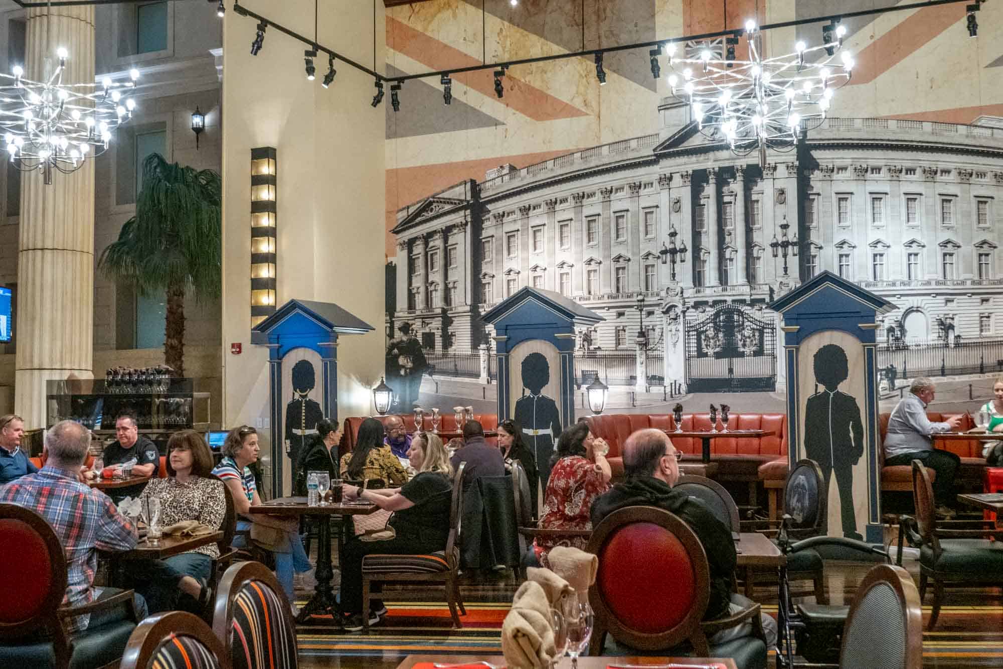 People in a restaurant with British-themed decorations, including images of the Queen's Guard.