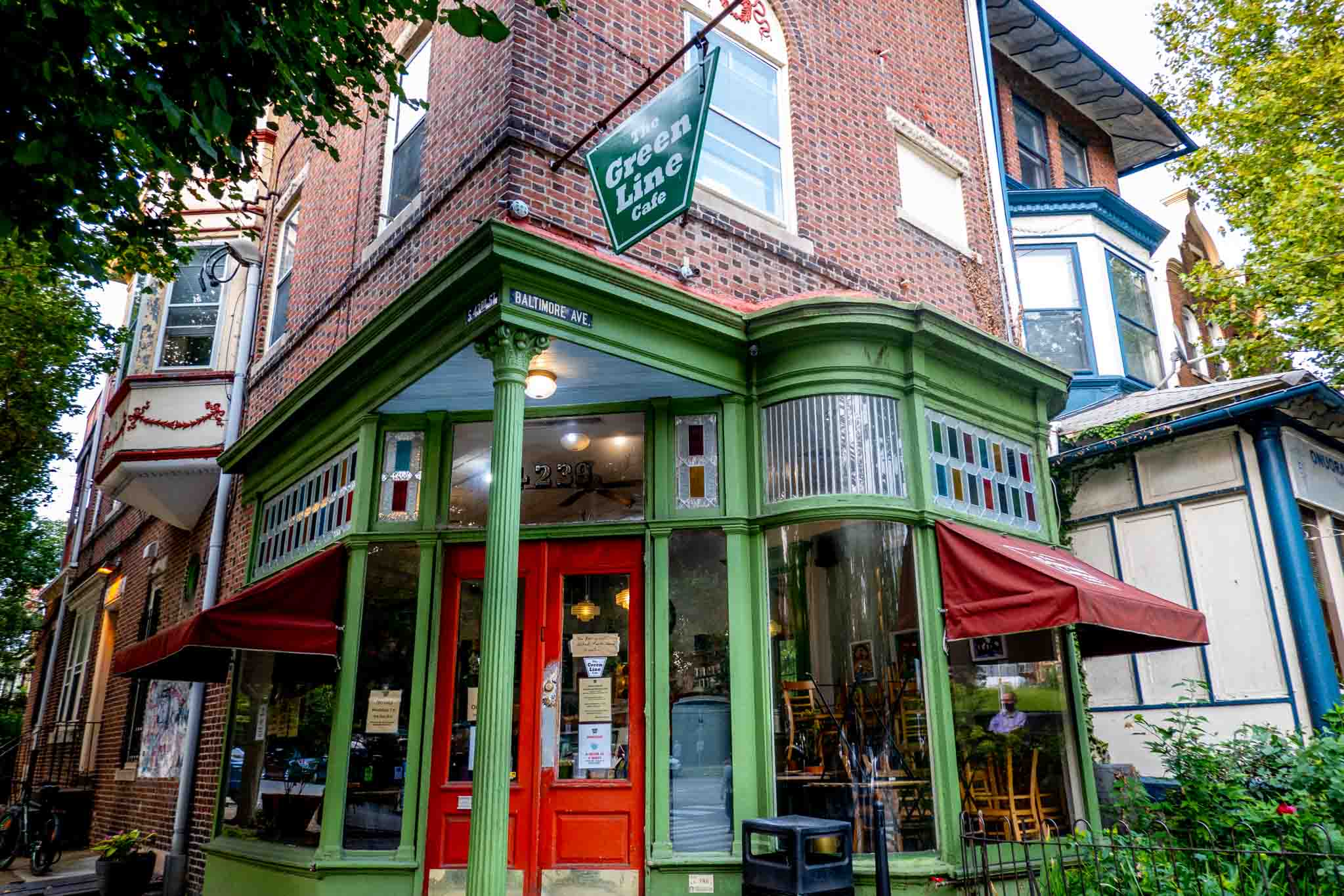 Exterior of a cafe painted red and green with a sign for "The Green Line Cafe."