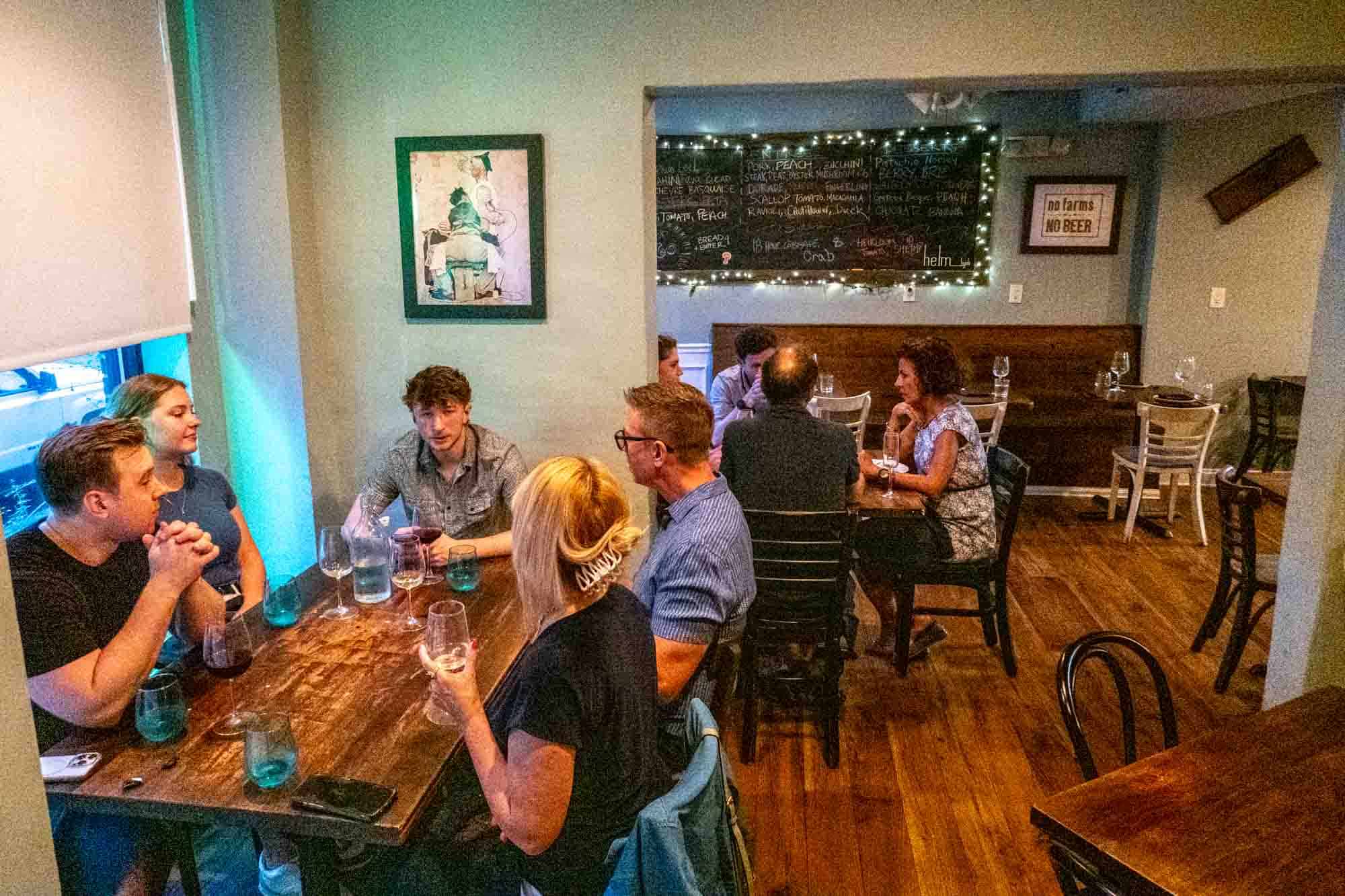 People sitting at wooden tables and chairs 