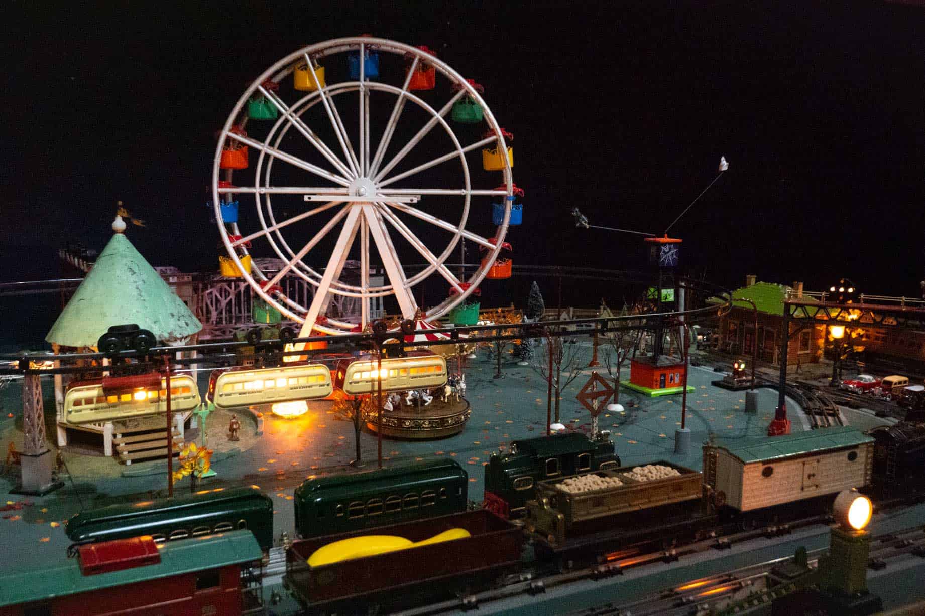 Miniature train circling a carnival scene