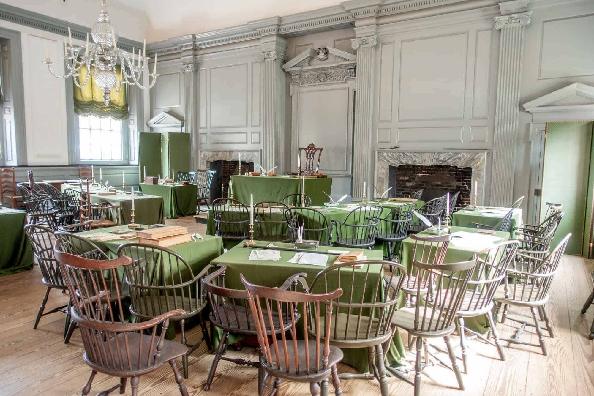 Room with chairs and tables covered in green tablecloths