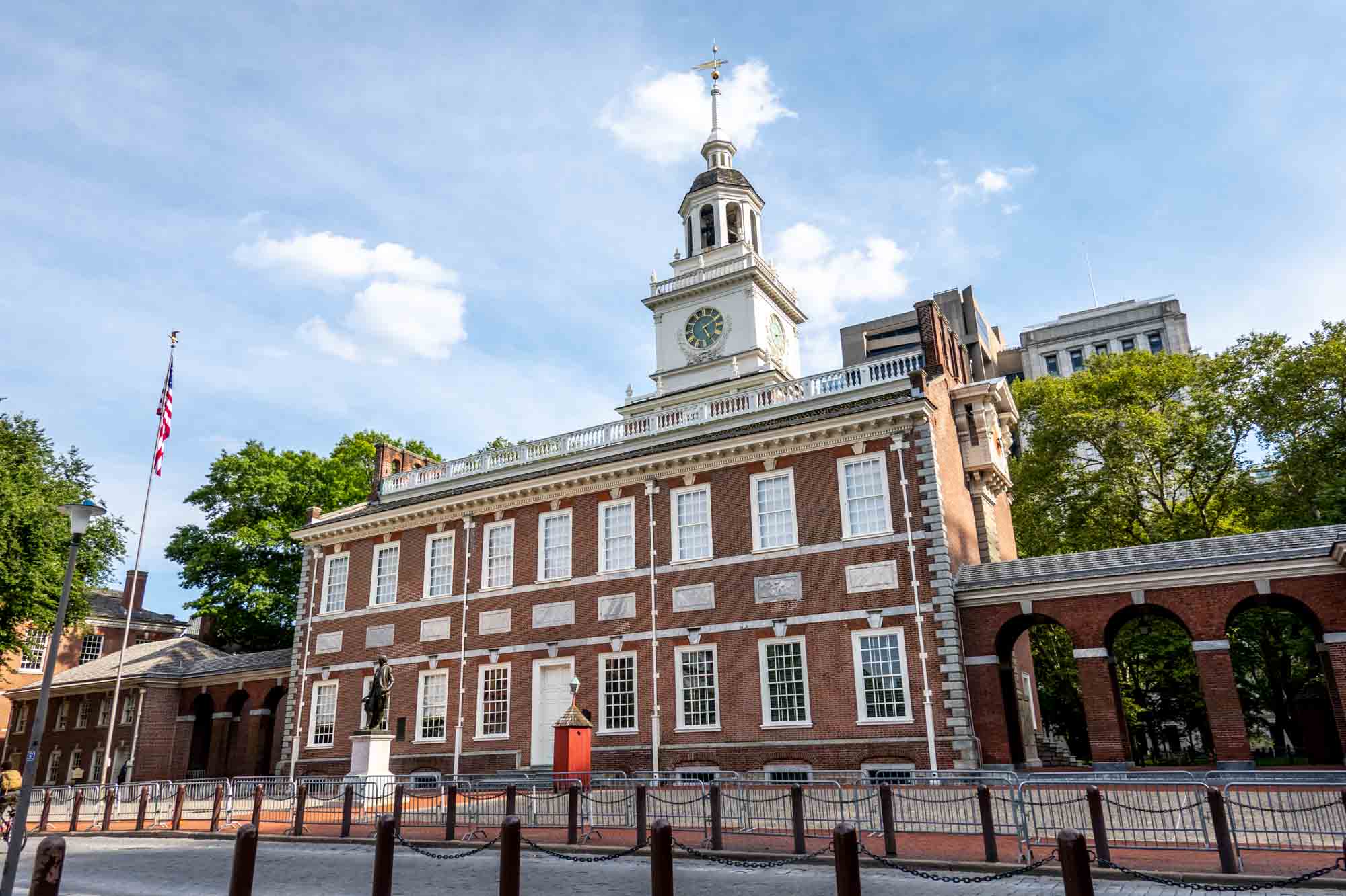 Large brick building with rows of windows and a white cupola with a clock.