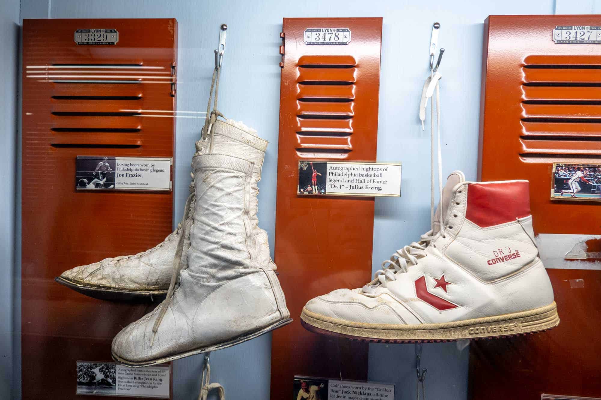 Pair of boots and pair of shoes in a display that mimics a locker room.