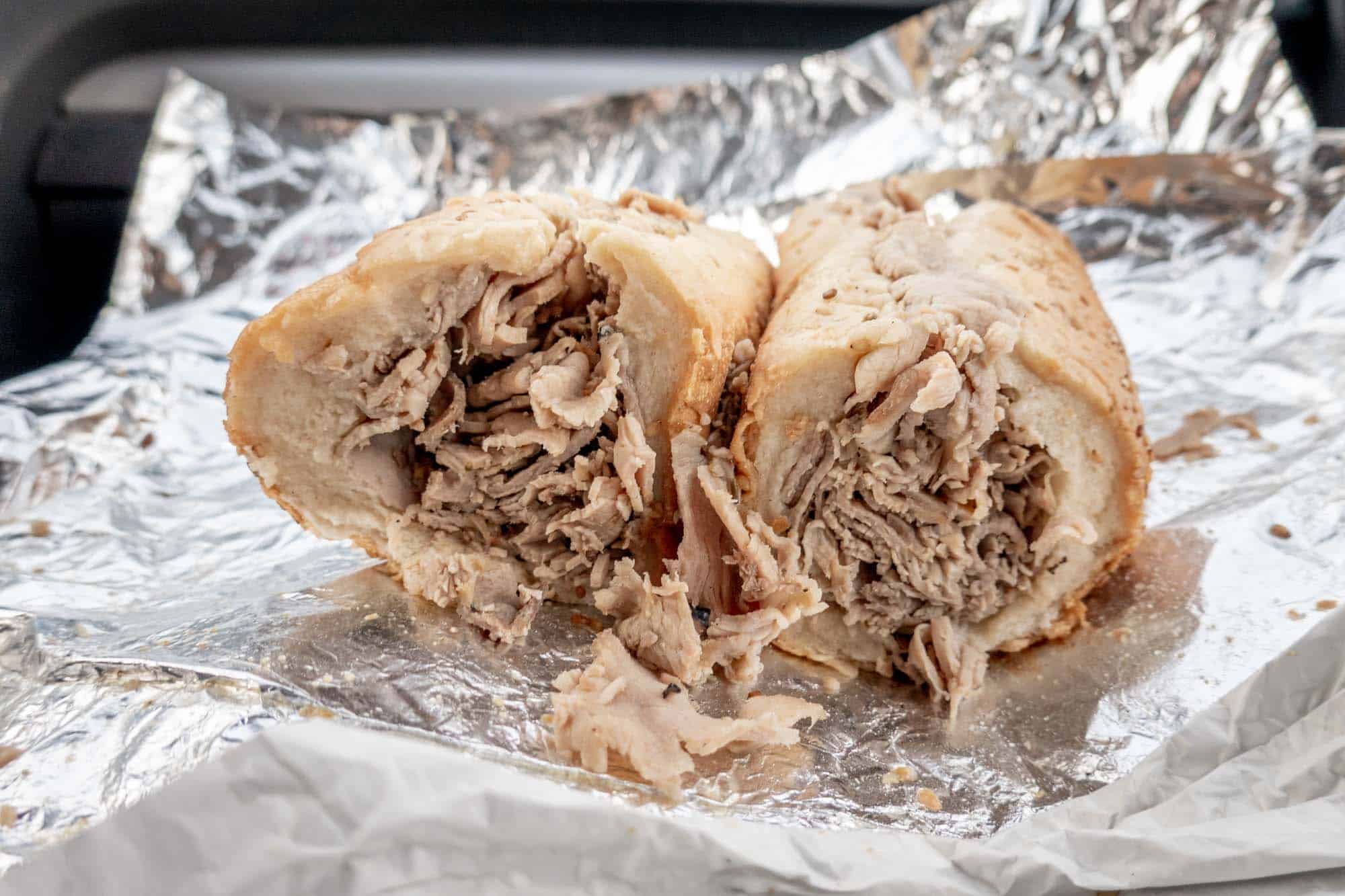 Thinly-sliced roast pork on a roll