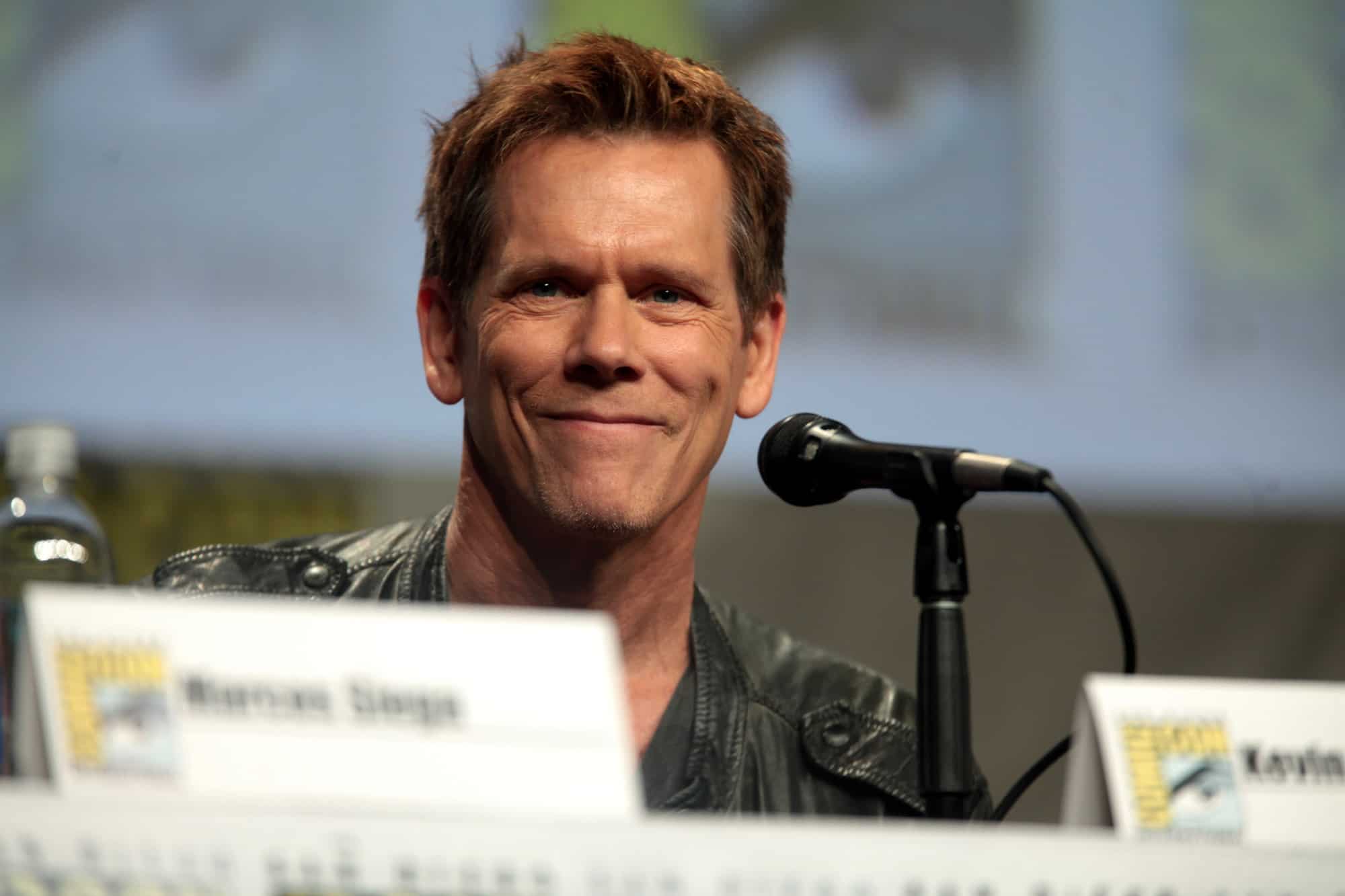 Kevin Bacon speaking at microphone