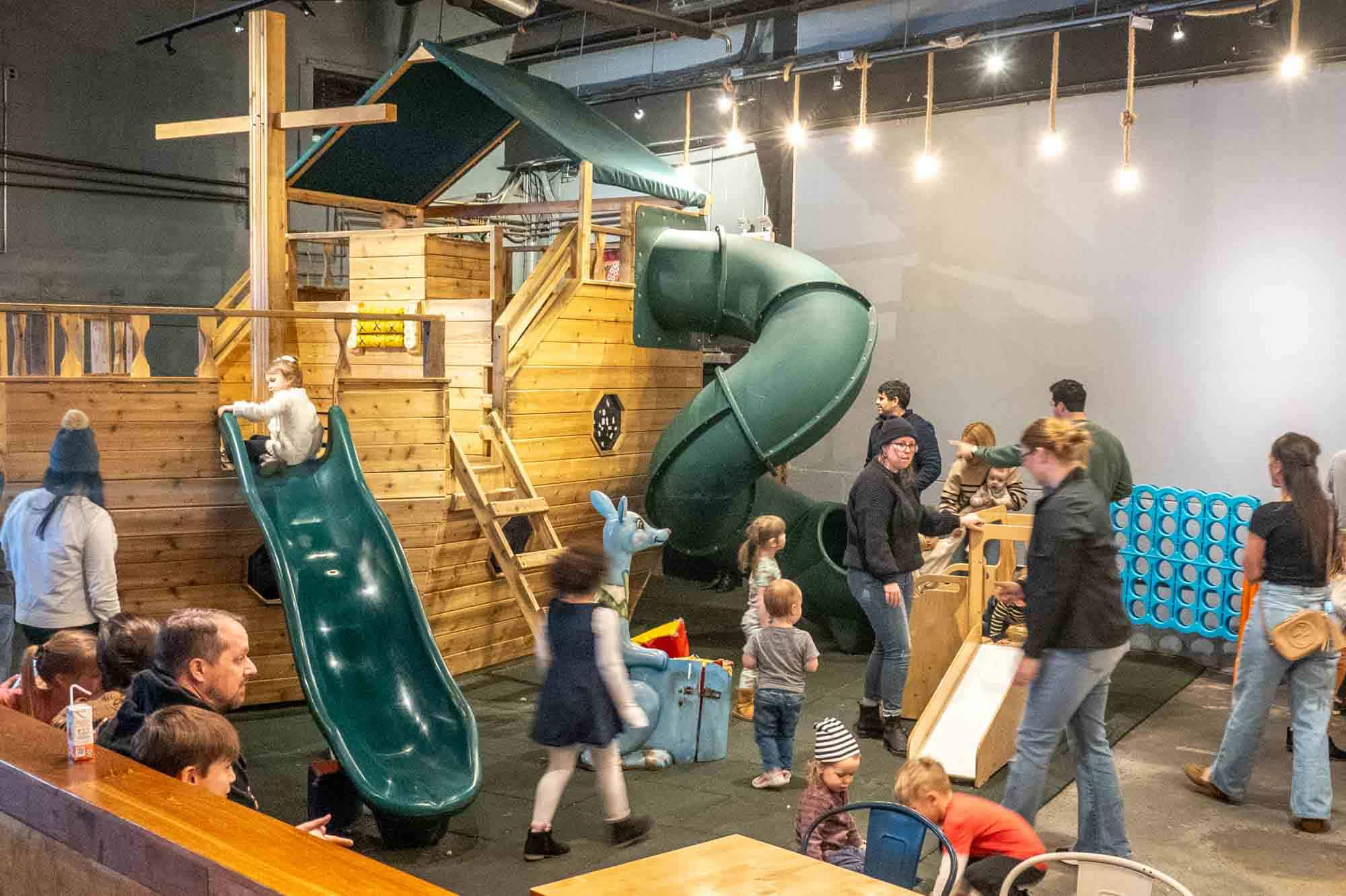 Kids playing on an indoor play structure.