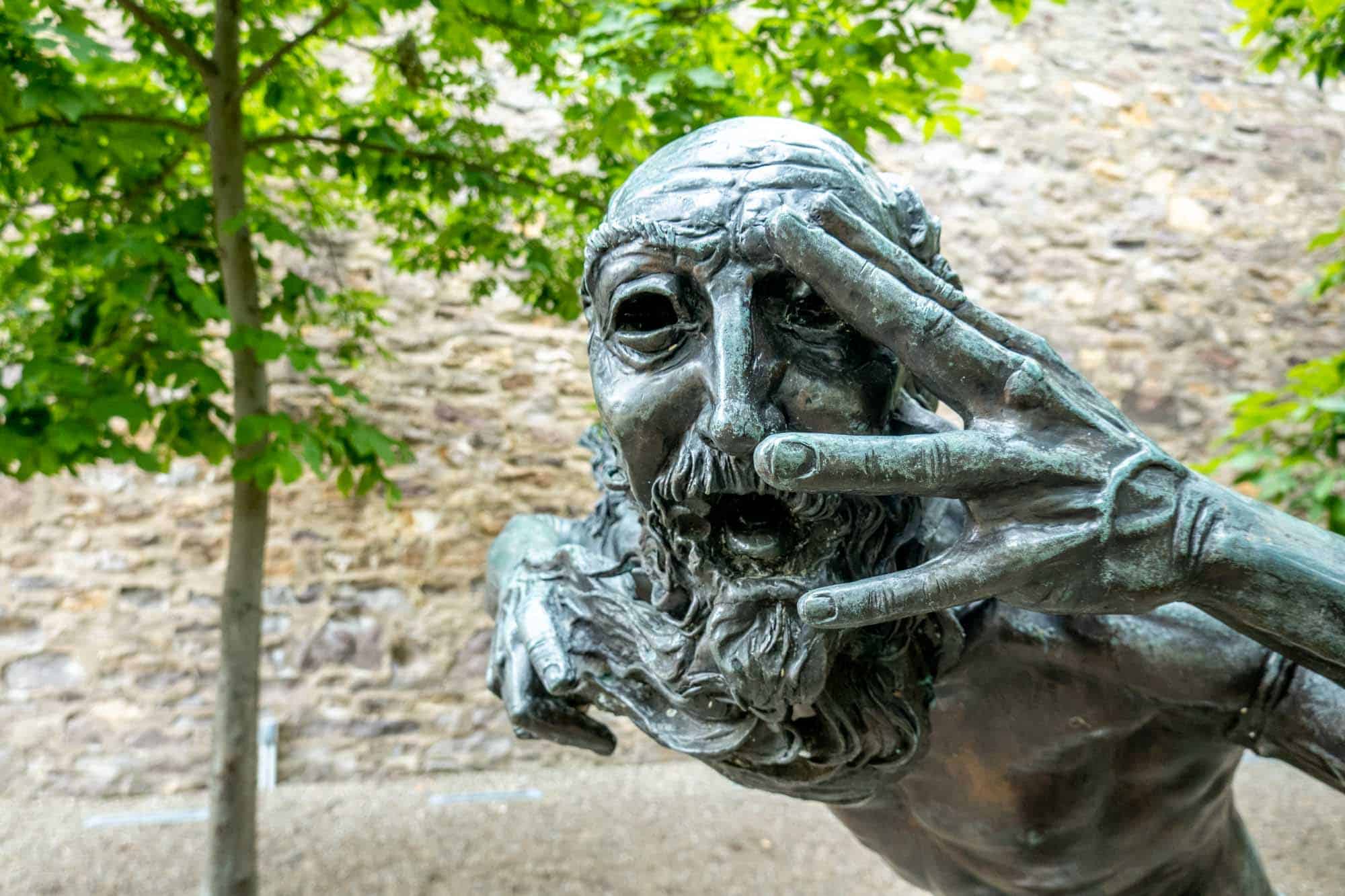 Sculpture of a man looking through his fingers