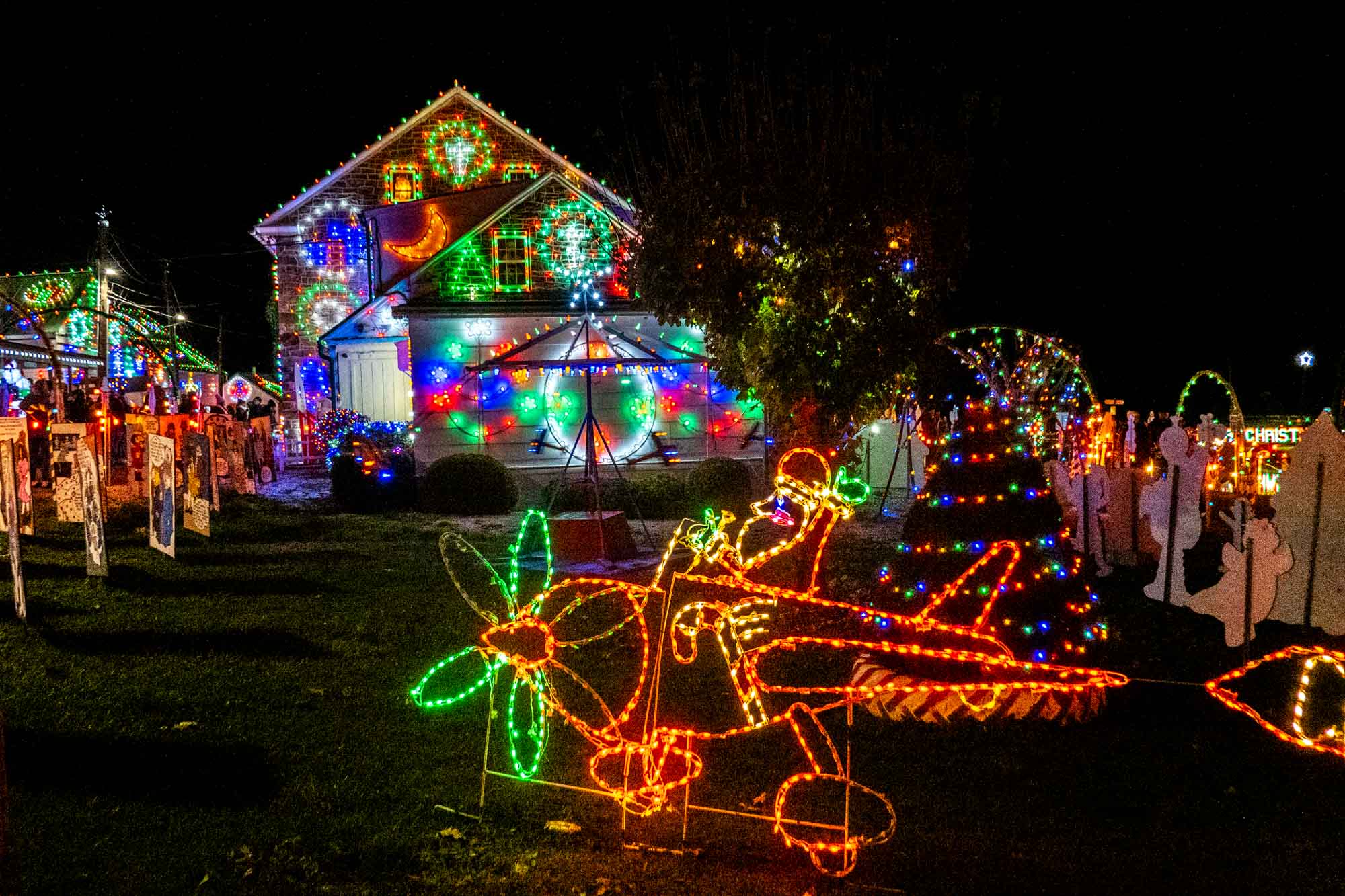 Christmas light display of Santa in an airplane and an illuminated house