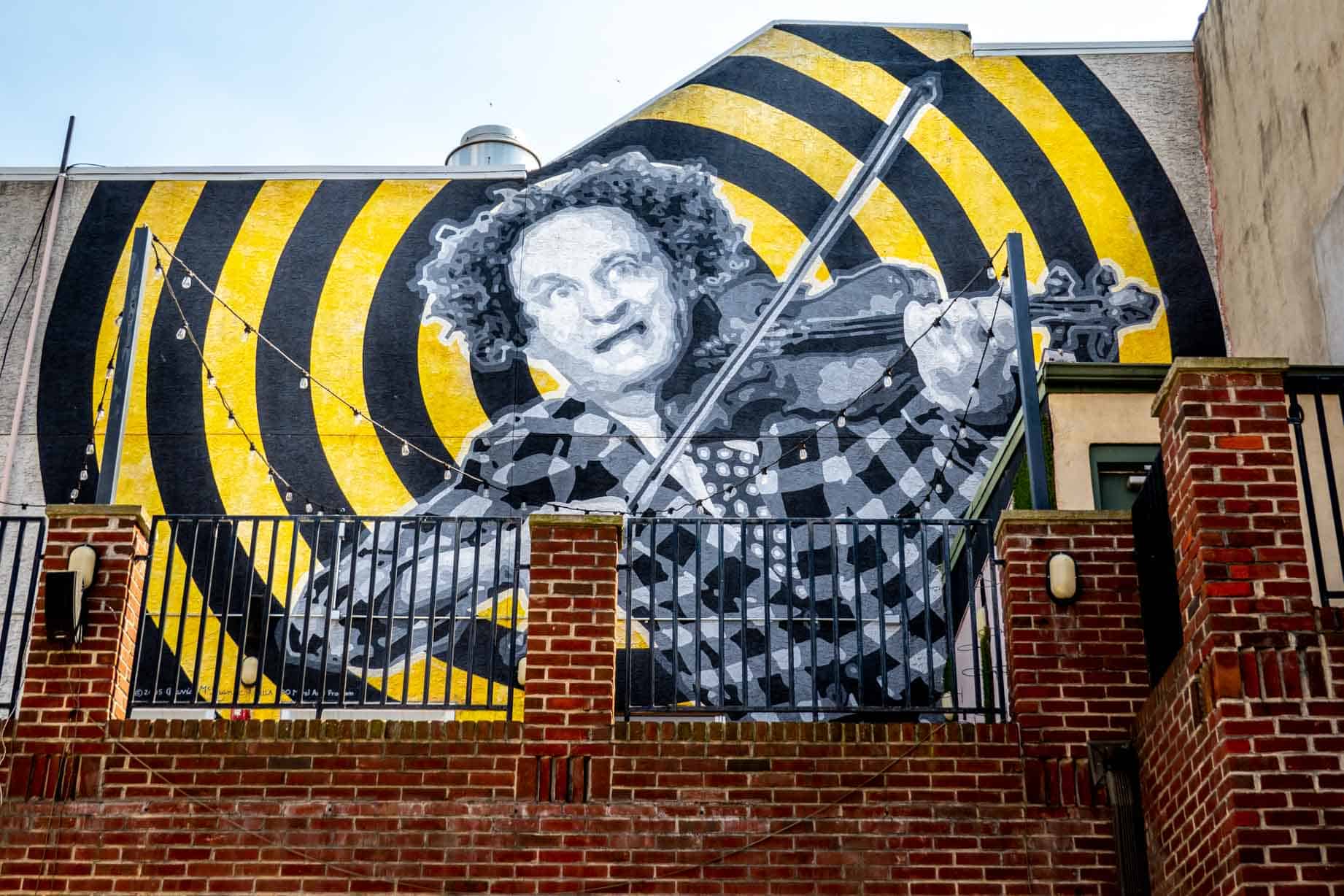 Mural of Larry Fine playing violin on wall on South Street above his boyhood home