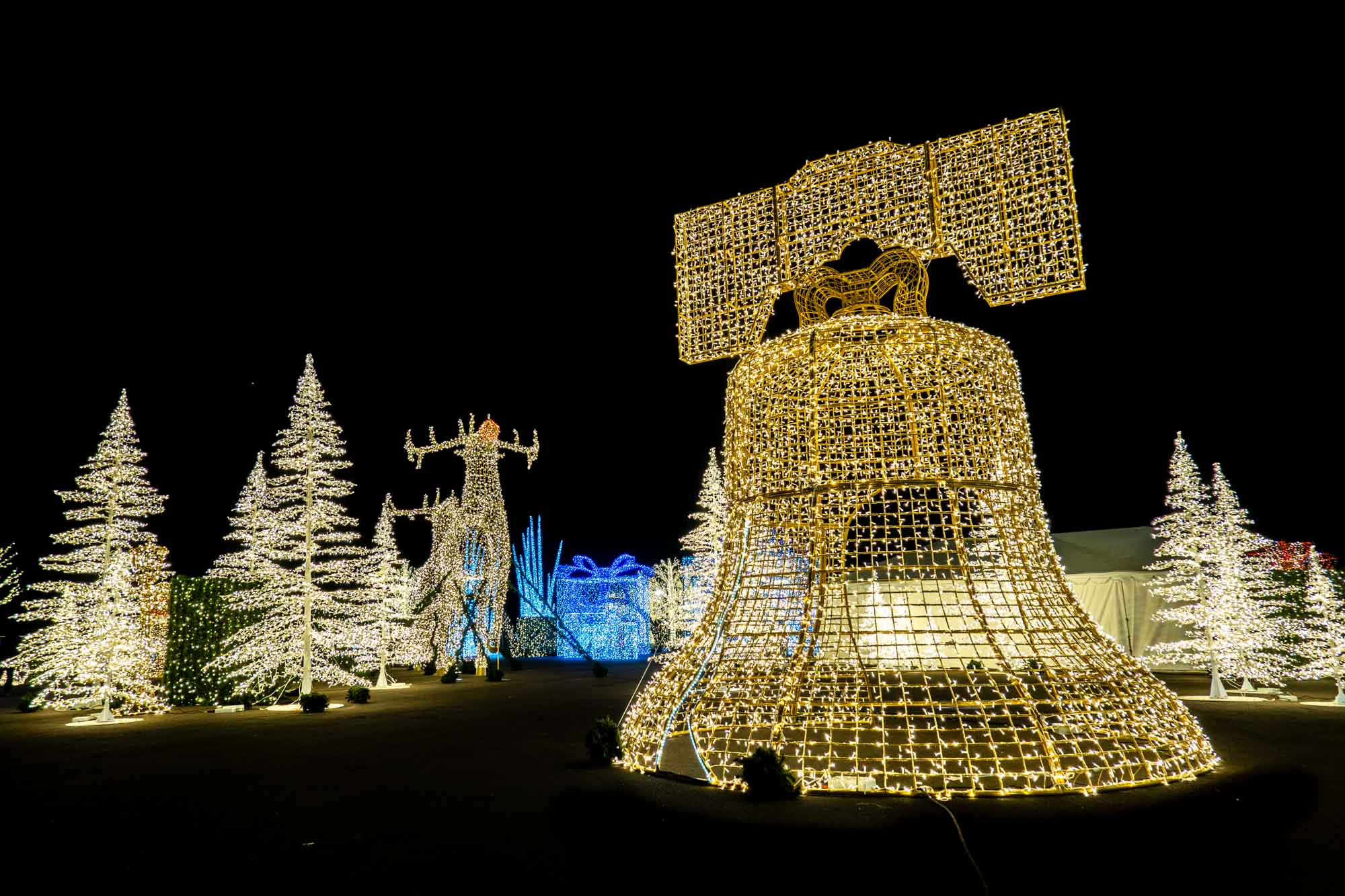 White Christmas lights in the shape of Christmas trees and a large bell