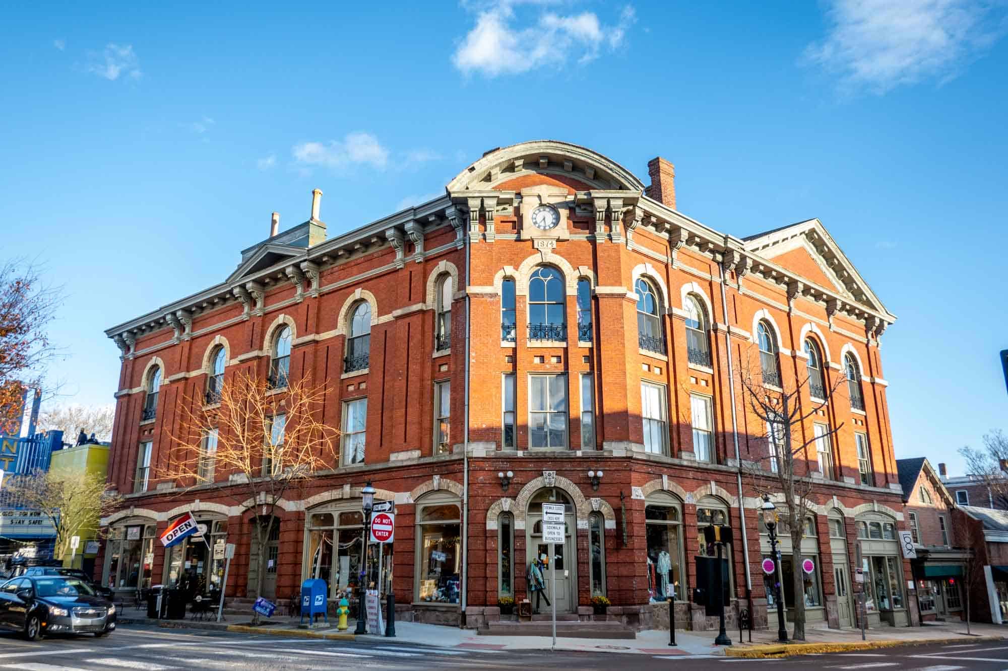 Three-story brick building with large windows. 