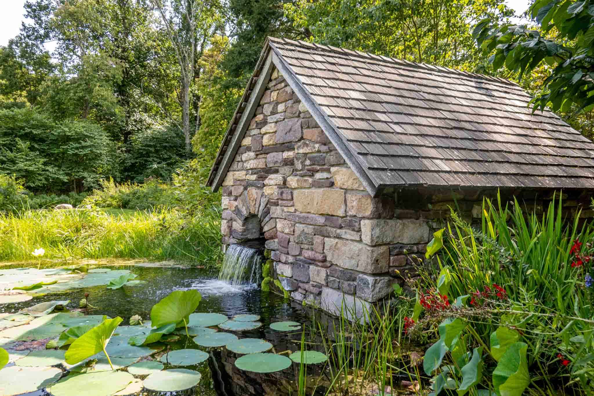 Stone hut in a pond with lily pads