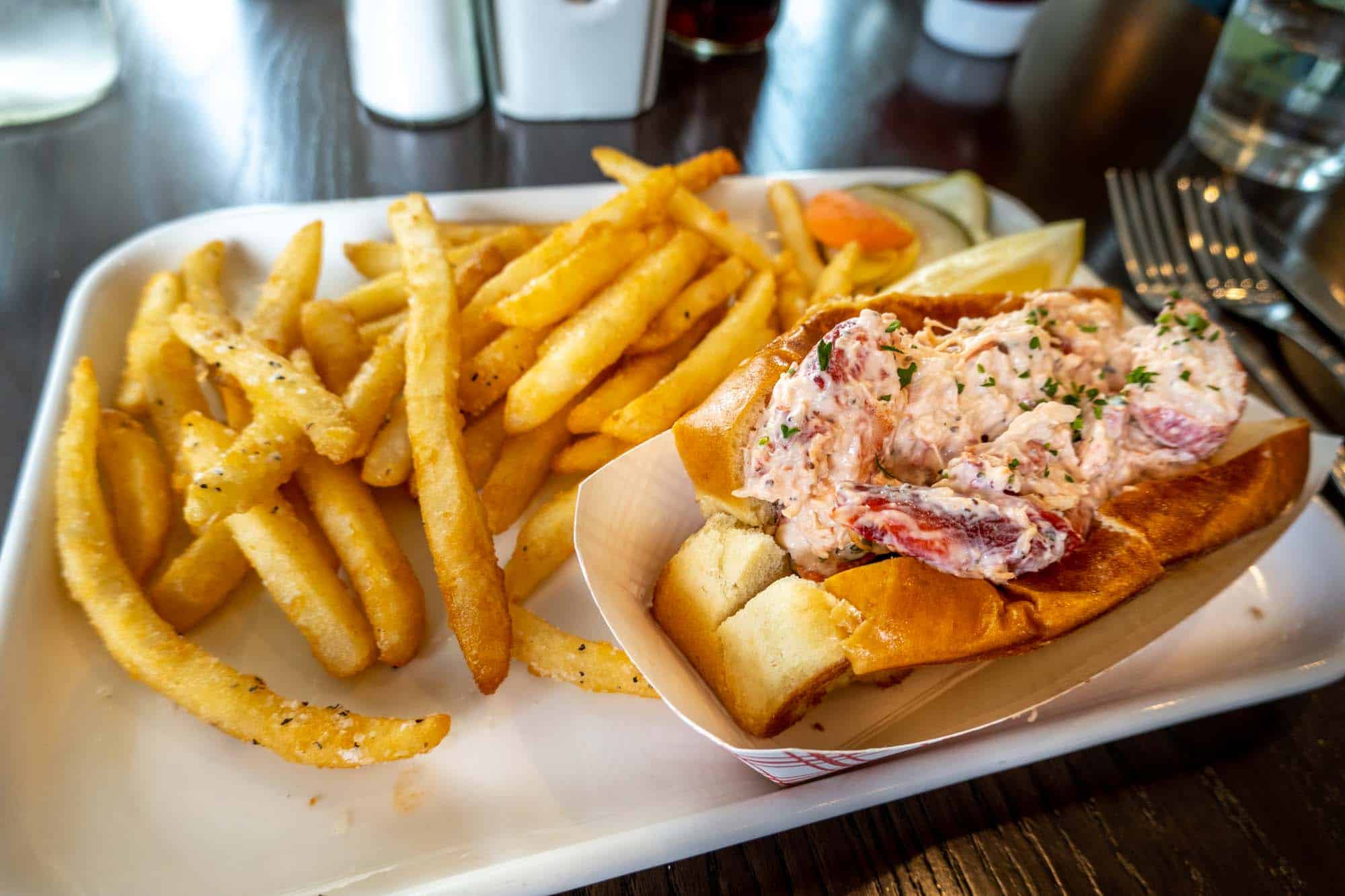 Lobster roll and French fries on a plate