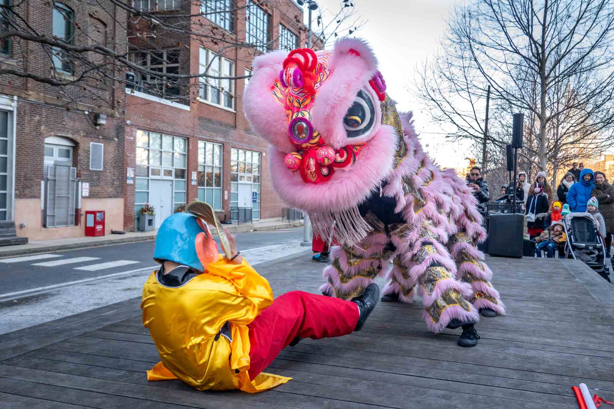 Traditional lion dance performers dressed in lion and man costumes.