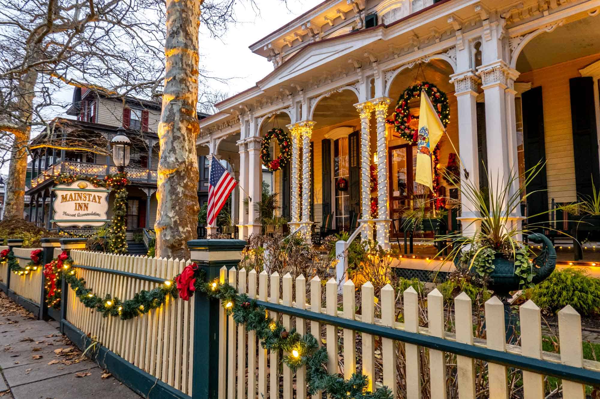 Victorian home decorated with Christmas lights and garland with a sign for the "Mainstay Inn."