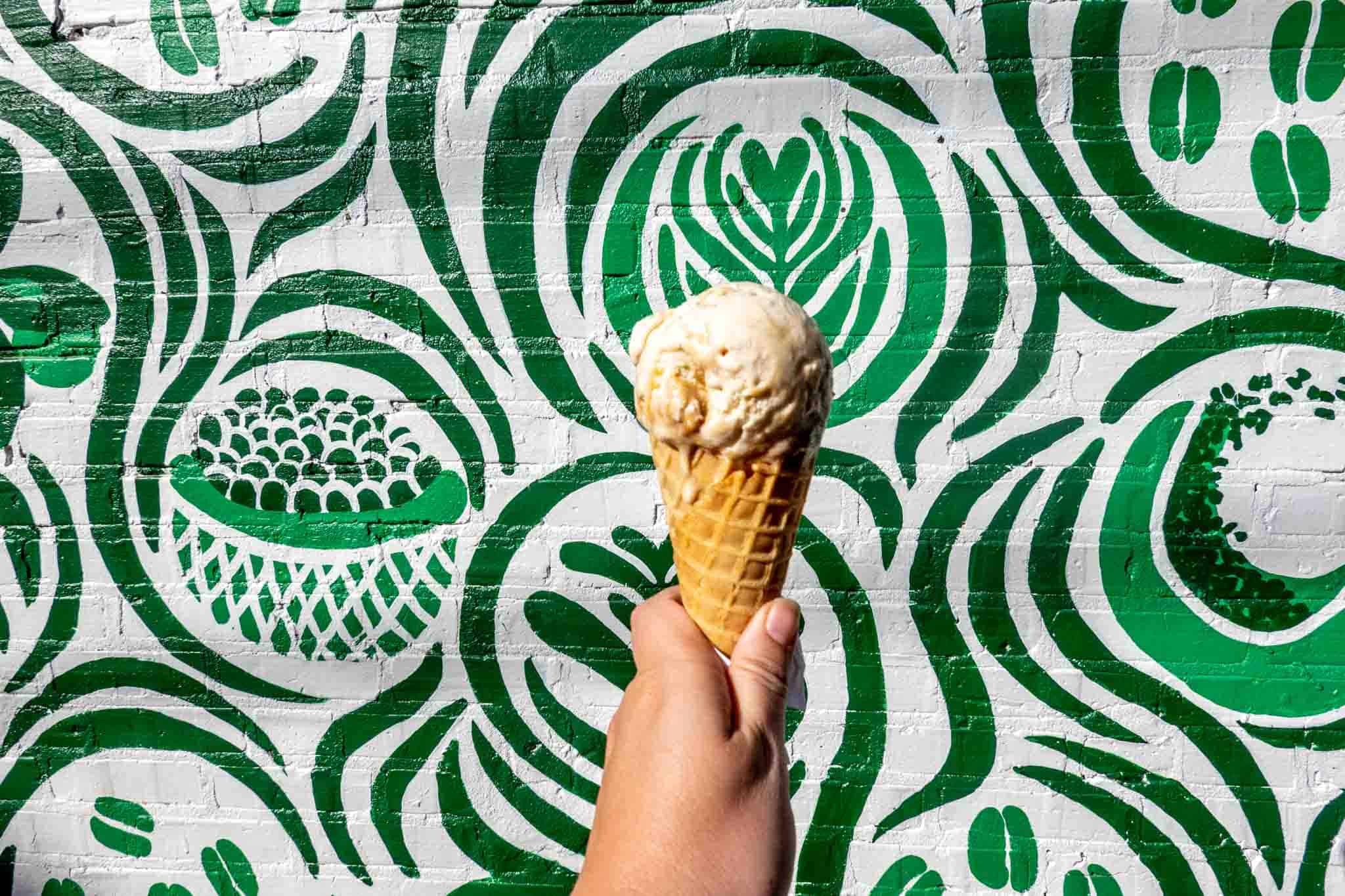 Ice cream cone in front of a green wall